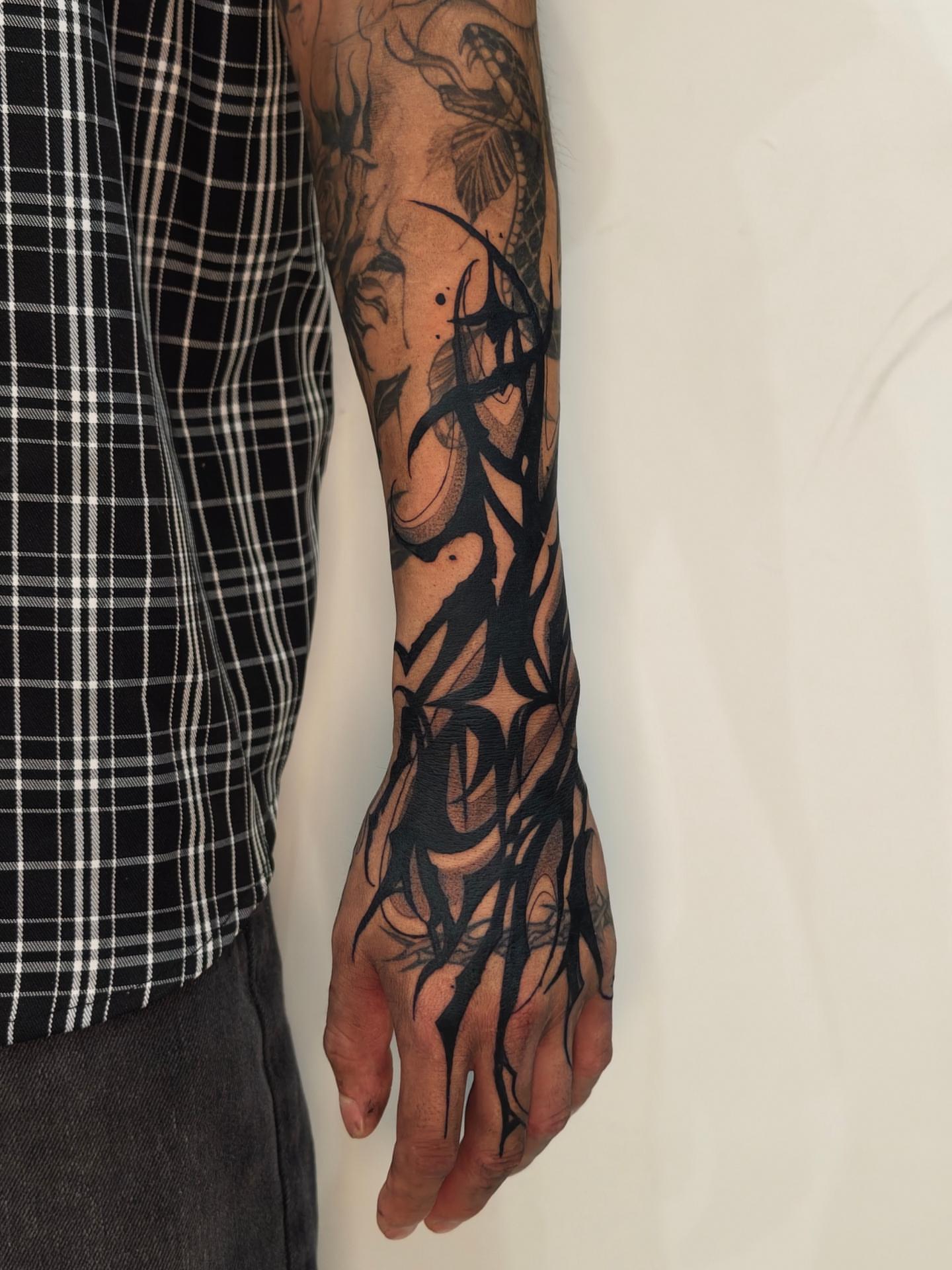 Abstract design black and grey tattoo on the upper arm by Jess Dominguez