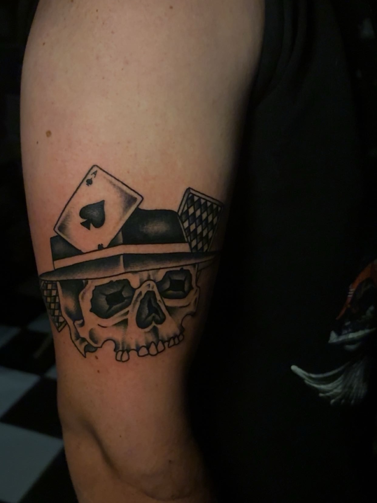 Skull with playing card black and grey tattoo on the forearm by Chris Prince Jr., Miamisburg, Ohio