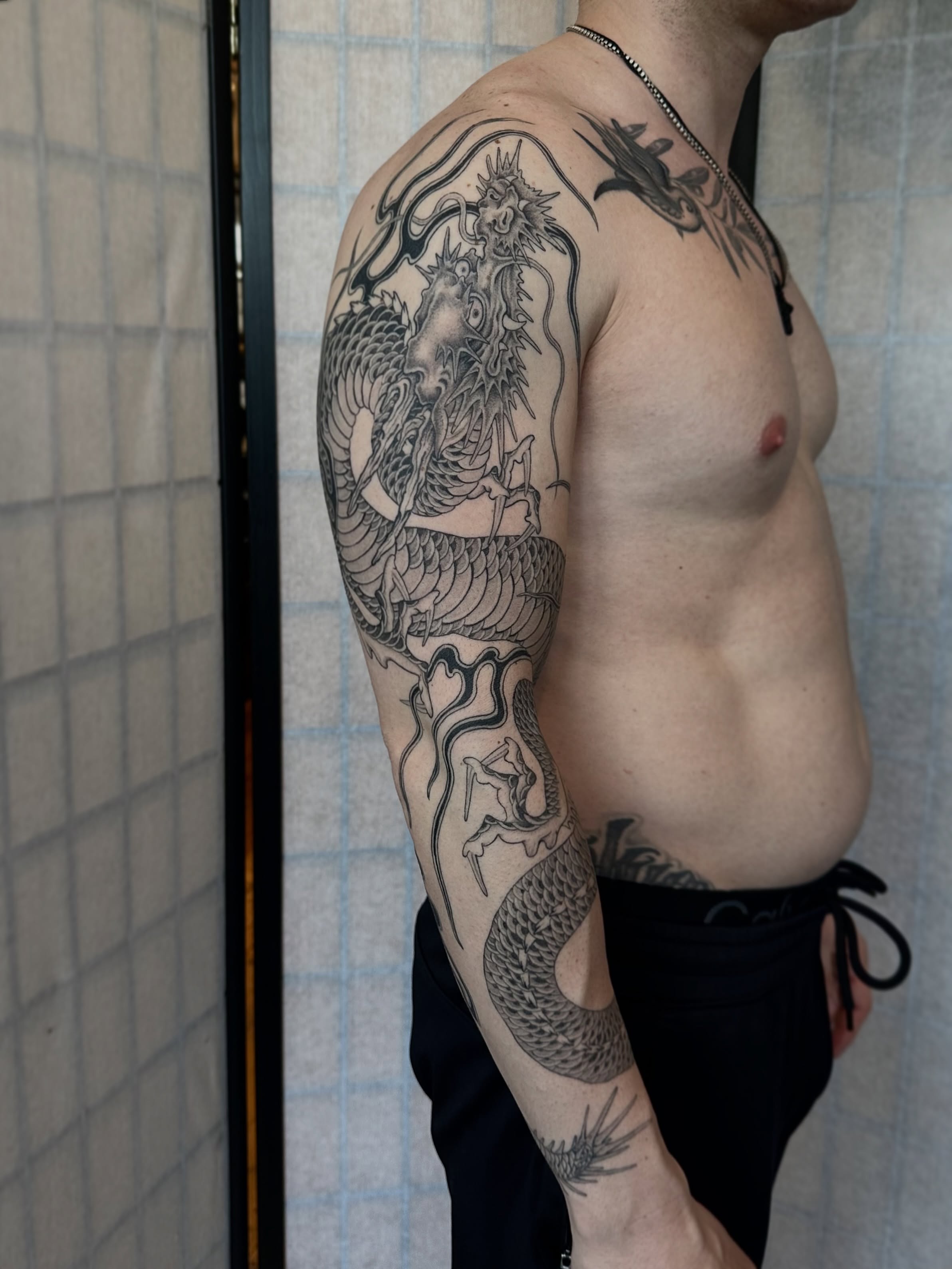 Dragon black and grey tattoo on the upper arm by Адріянна Стабс 🇺🇦, New York, New York