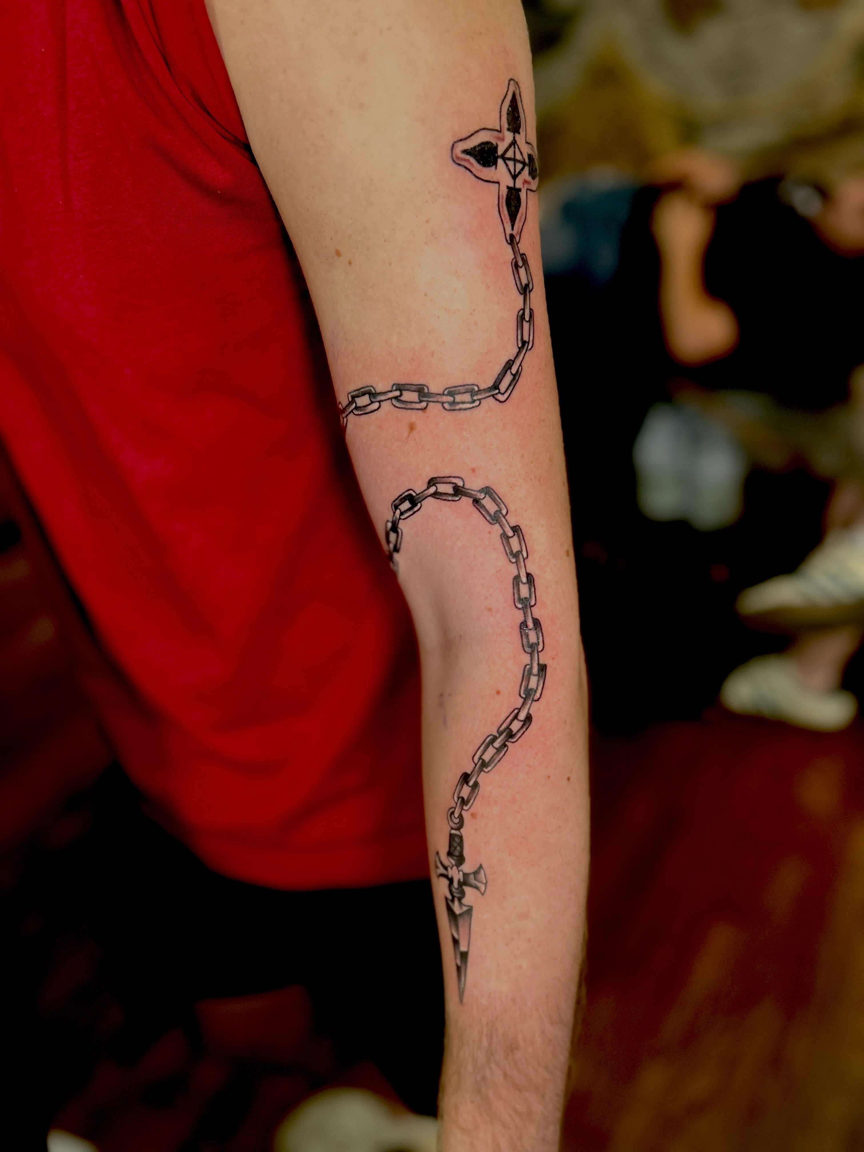 Chains and dagger black and grey tattoo on the forearm by Austin Young