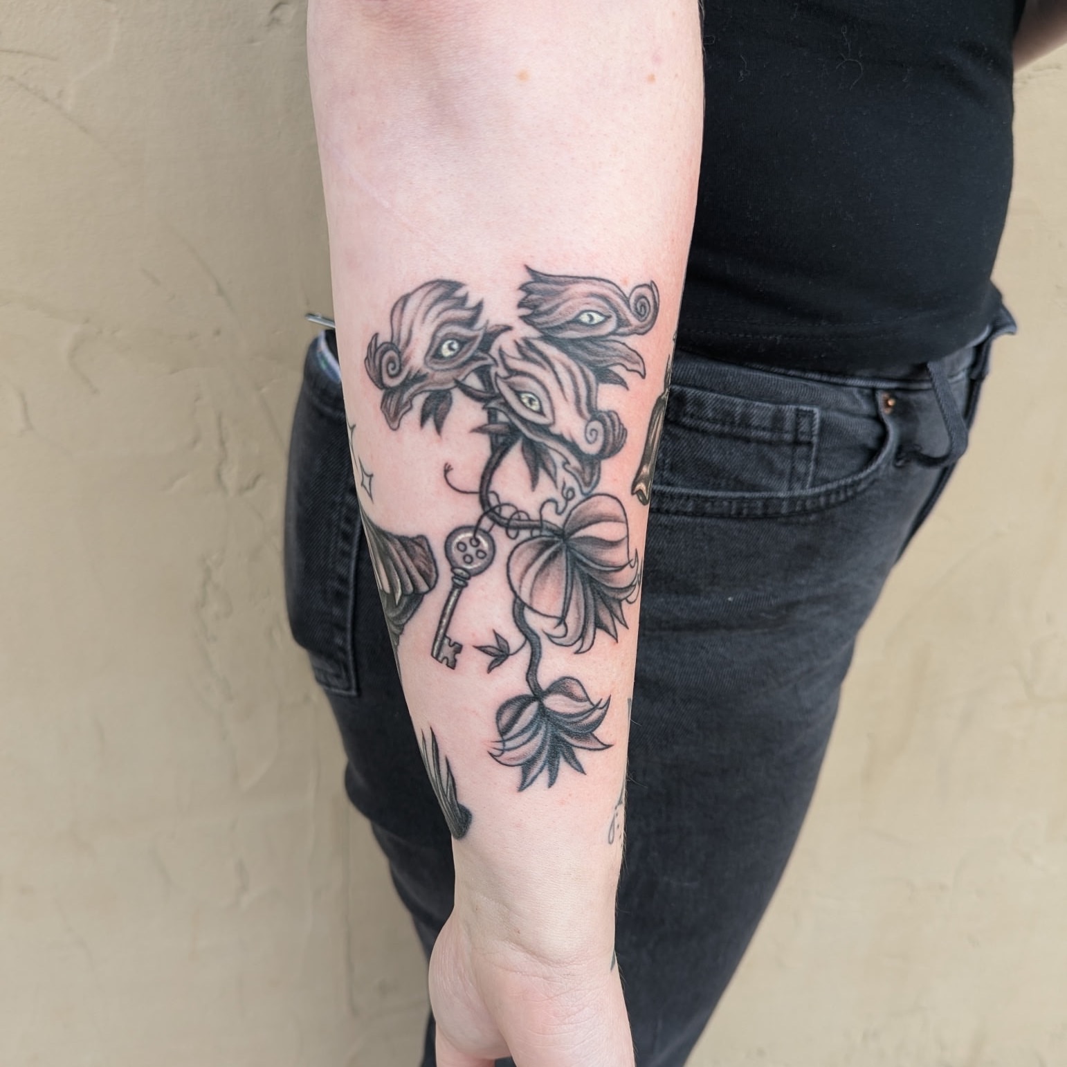 Mask and key black and grey tattoo on the forearm by Raven FM-Tattoo Apprentice