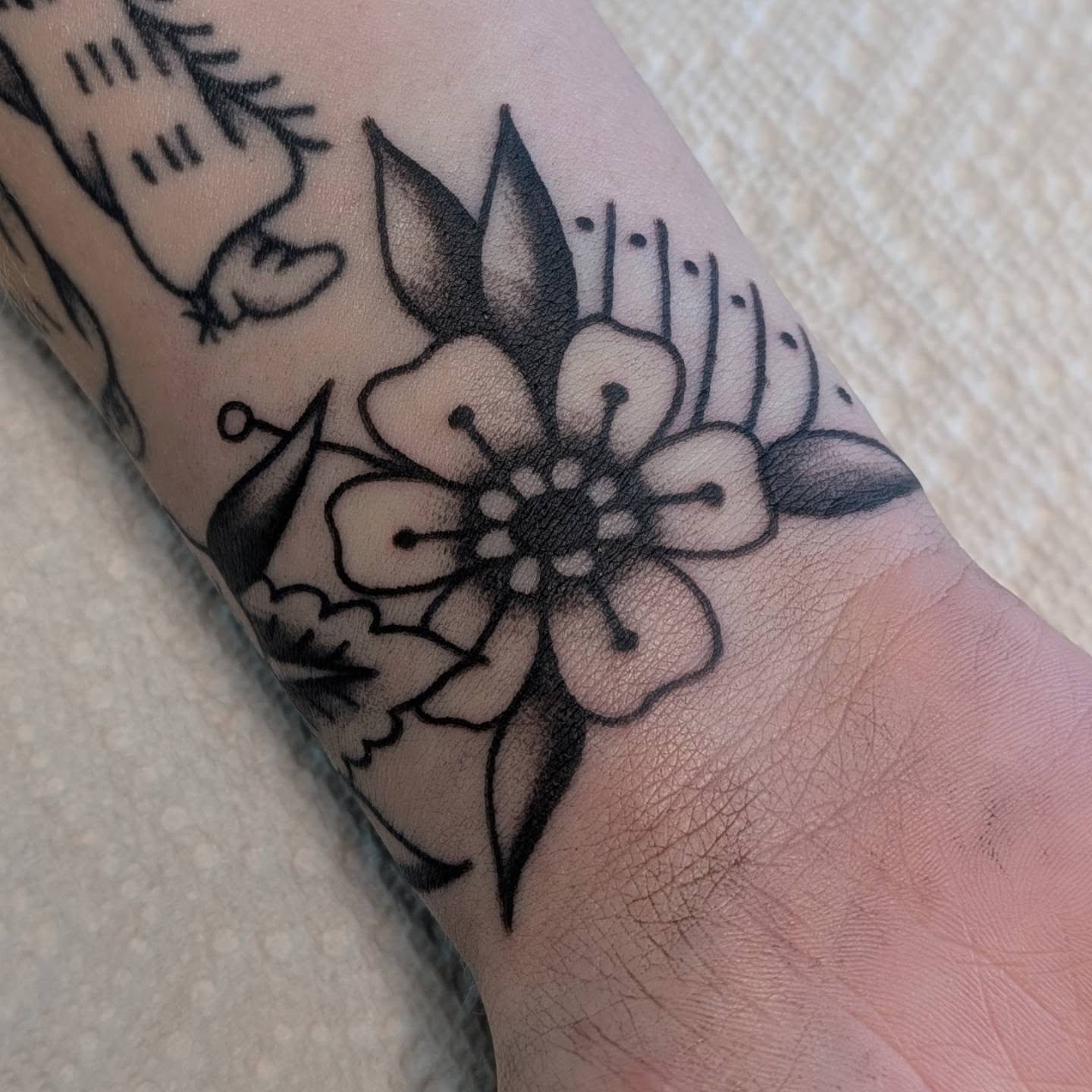 Flower black and grey tattoo on the forearm by Alexandria Green