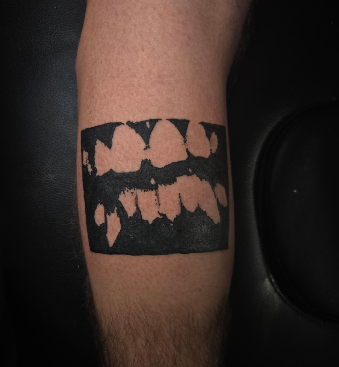 Batman logo black and grey tattoo on the forearm by Lane