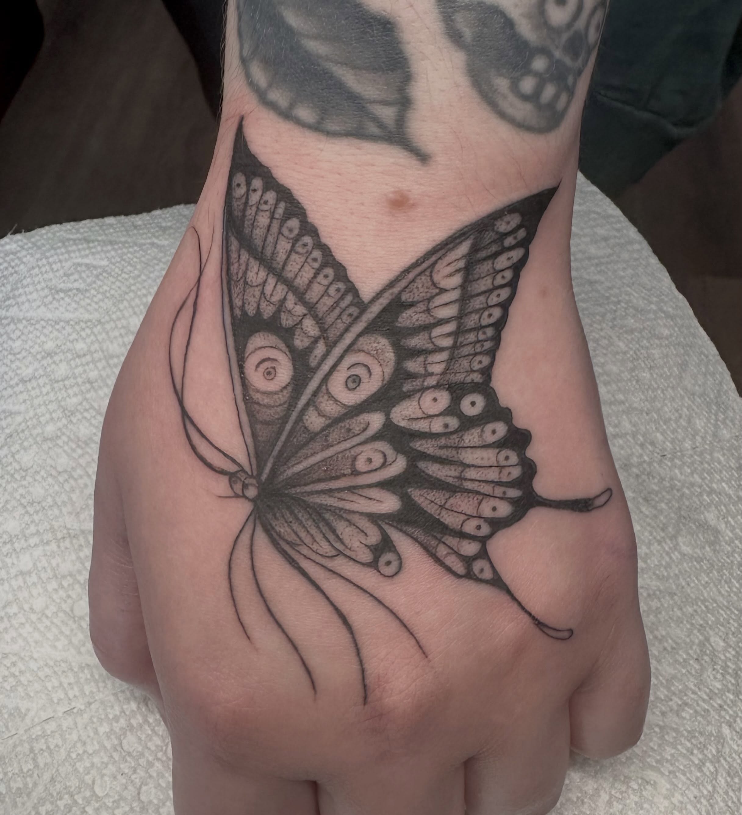 Butterfly dotwork tattoo on the hand by Lia Massari