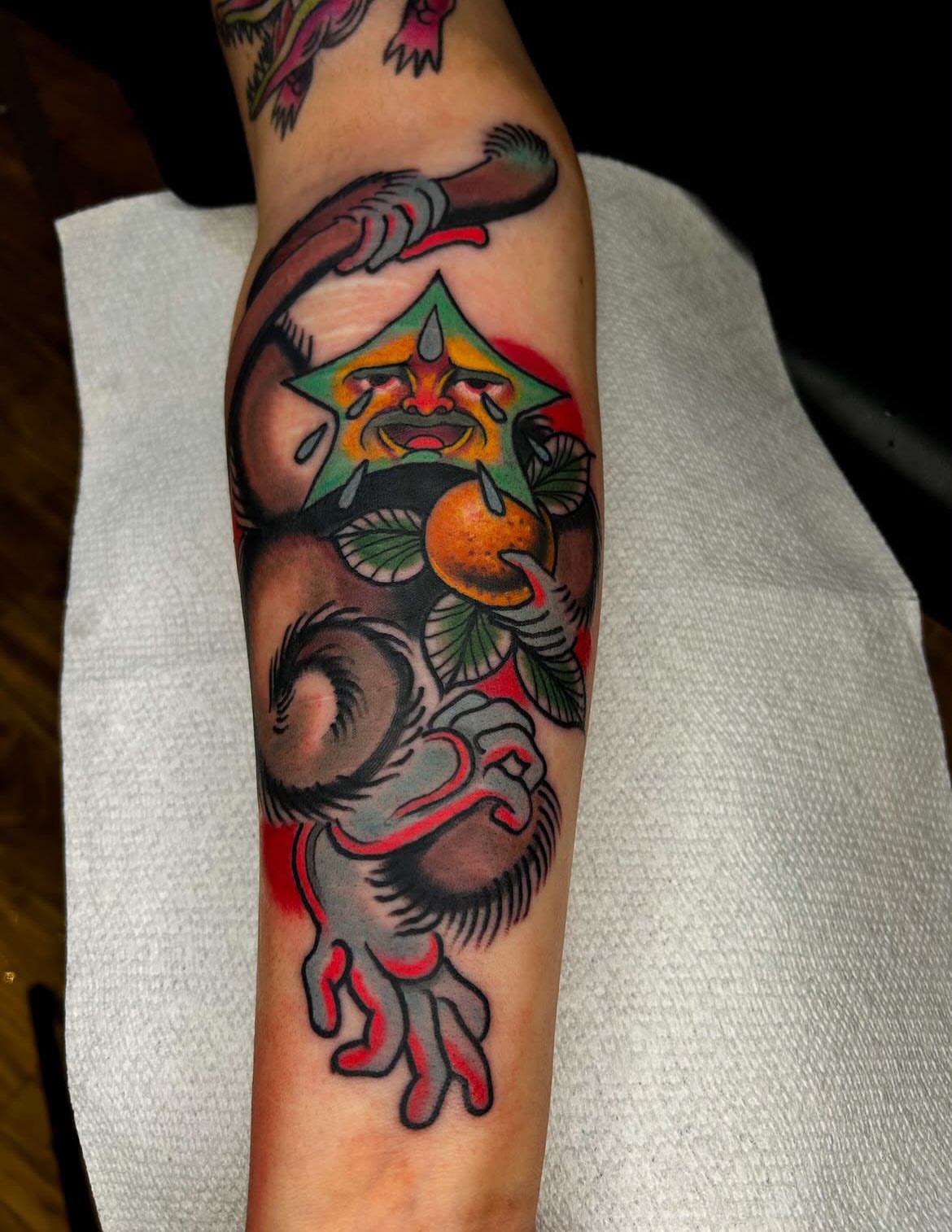 Monkey with fruit American traditional tattoo on the forearm by Samuel Dickey