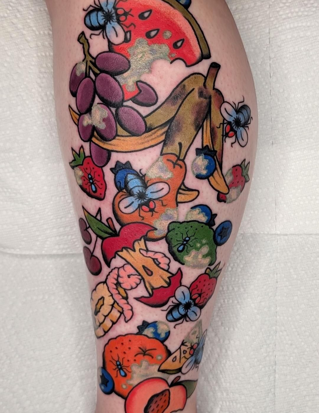 Fruit and flowers American traditional tattoo on the calf by Samuel Dickey