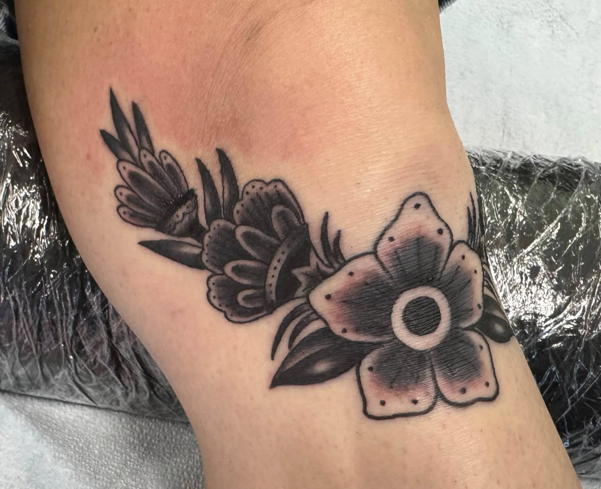 Flower black and grey tattoo on the forearm by Skott Kautman, Dubuque, Iowa