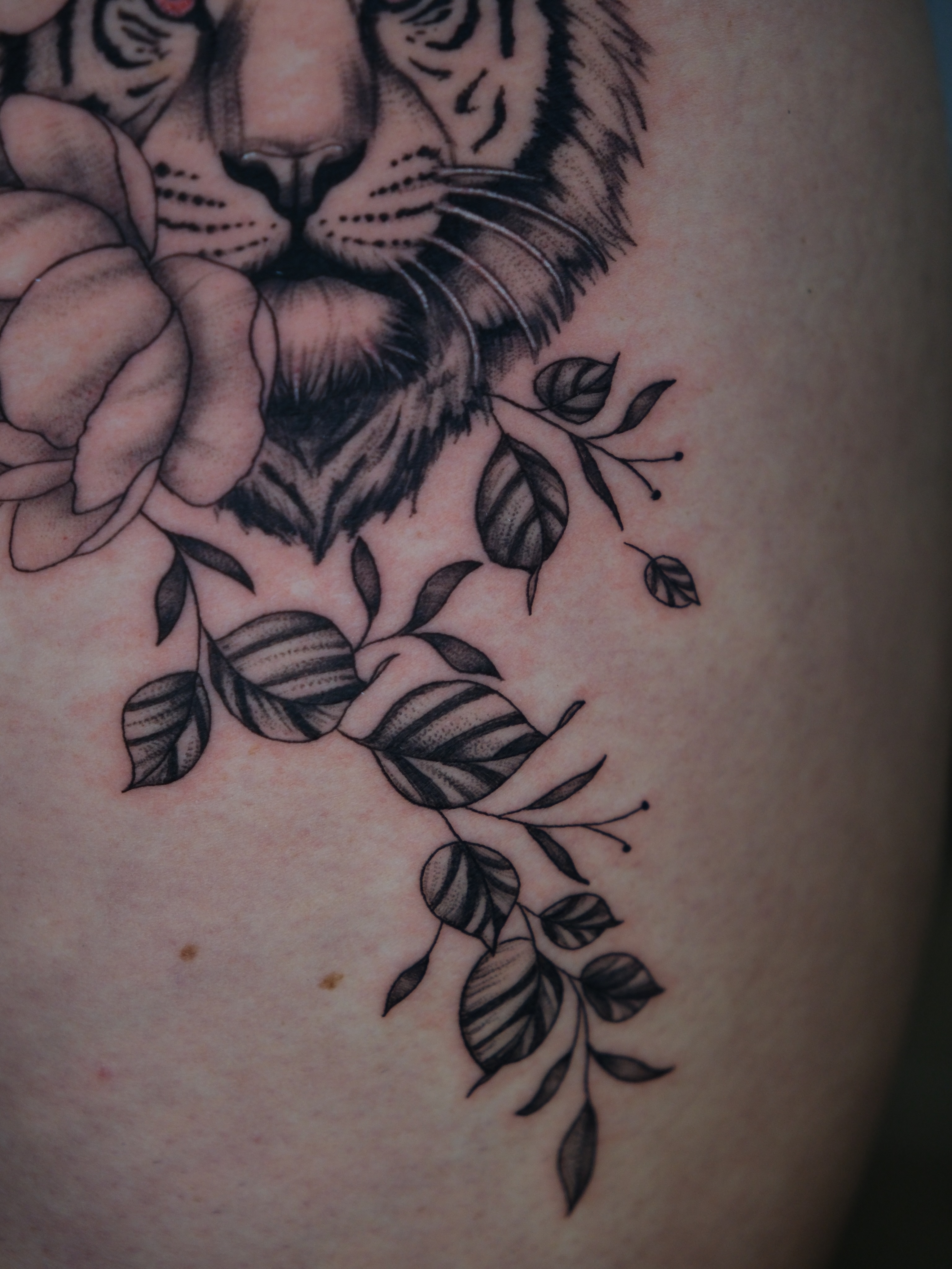 Tiger and rose realism tattoo on the thigh by Kiana Hope