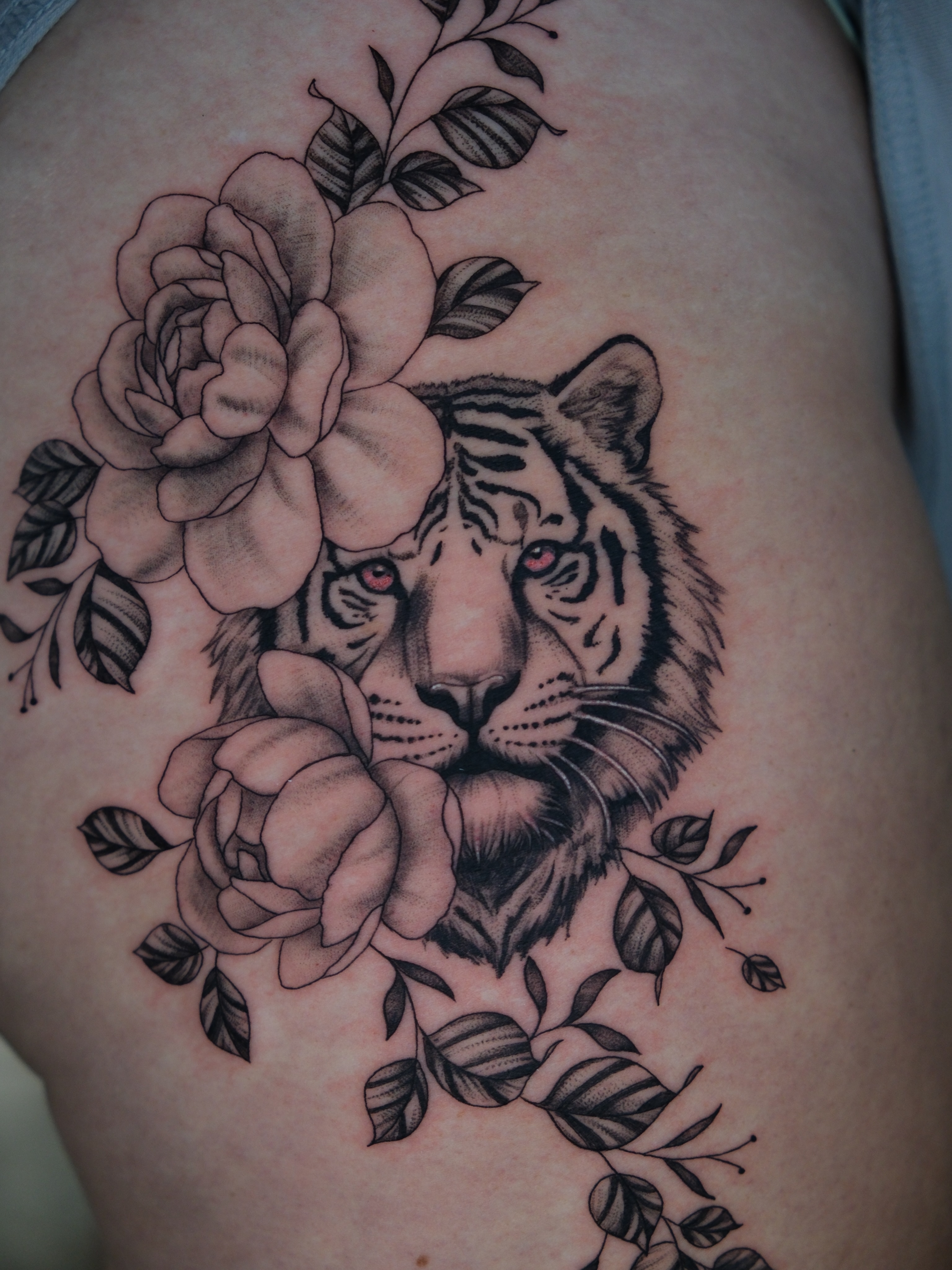 Tiger and roses realism tattoo on the thigh by Kiana Hope