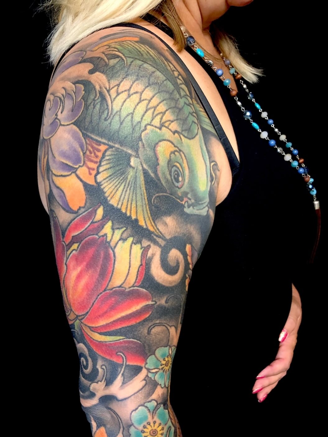 Koi fish and flowers japanese irezumi tattoo on the upper arm by jonhighland