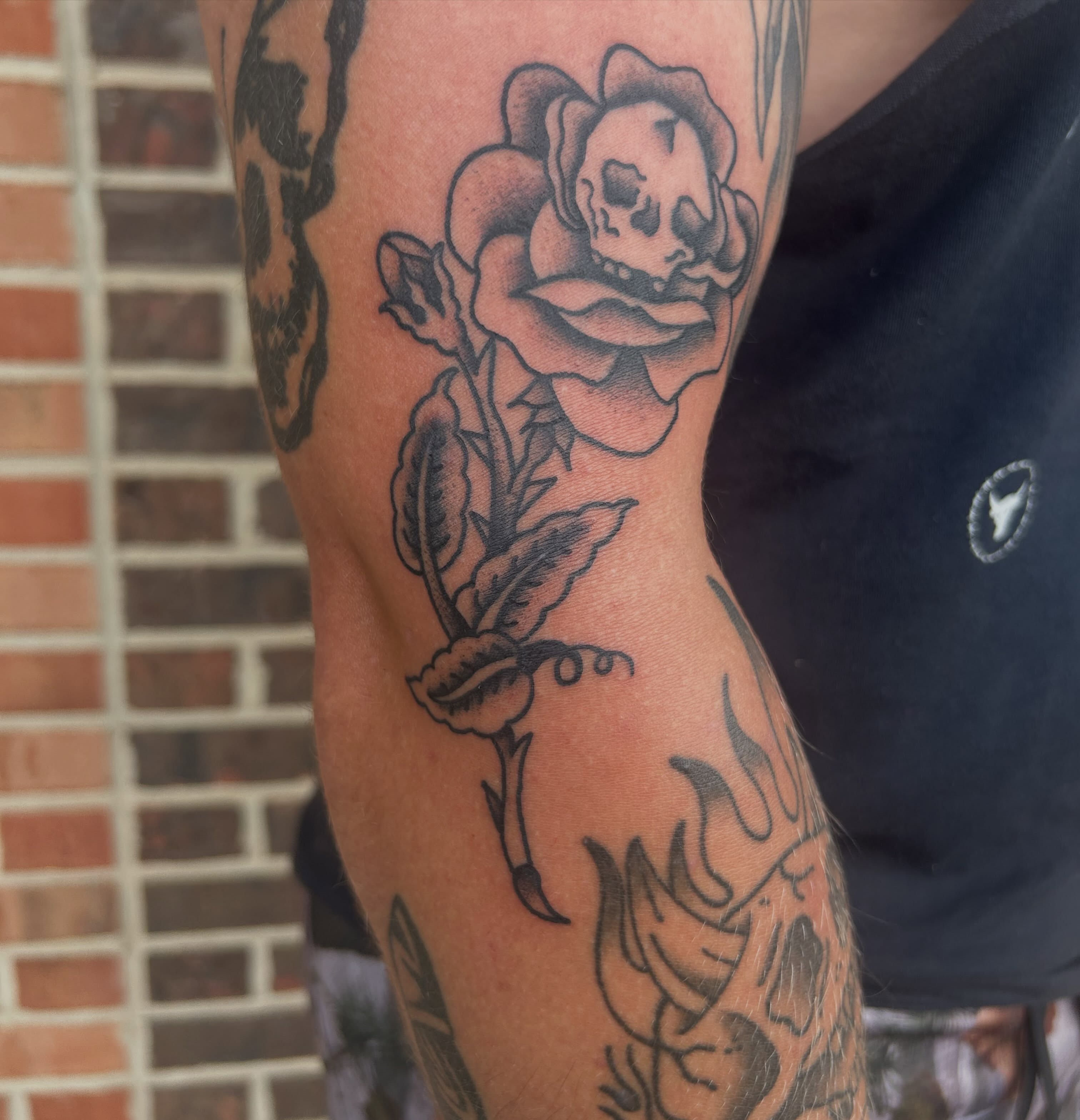 Rose with skull black and grey tattoo on the forearm by Zach Andrews