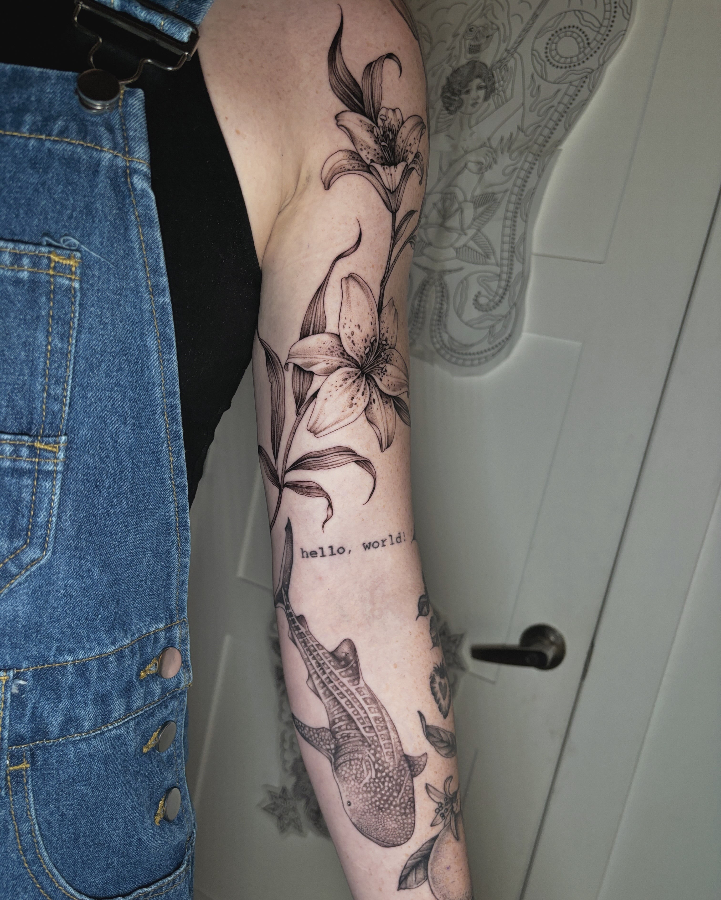 Lilies and crocodile realism tattoo on the forearm by Emma Cotter