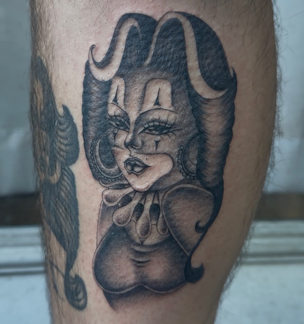 Clown black and grey tattoo on the forearm by H e I D I
