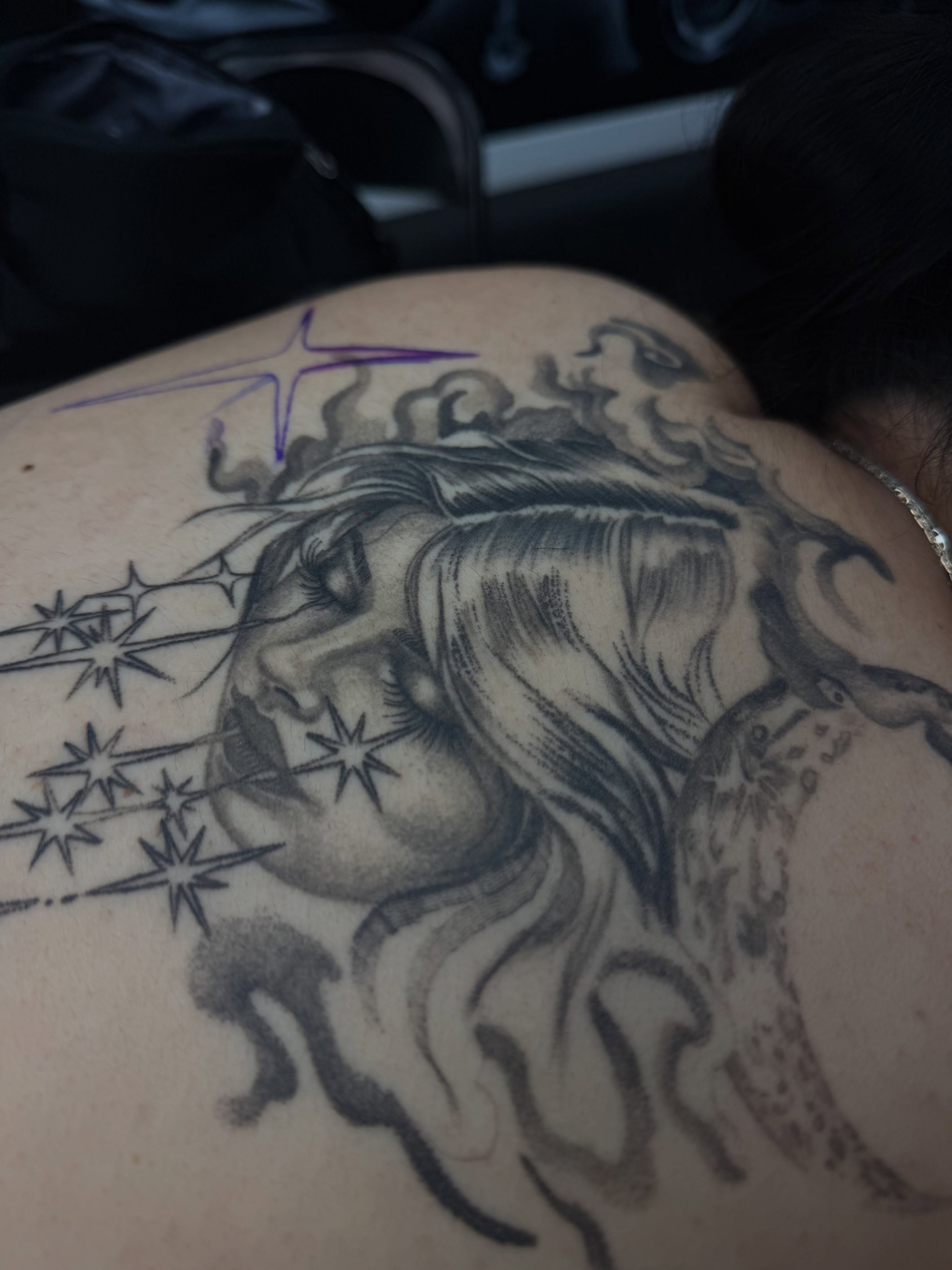 Woman blowing stars realism tattoo on the back by Yvonne