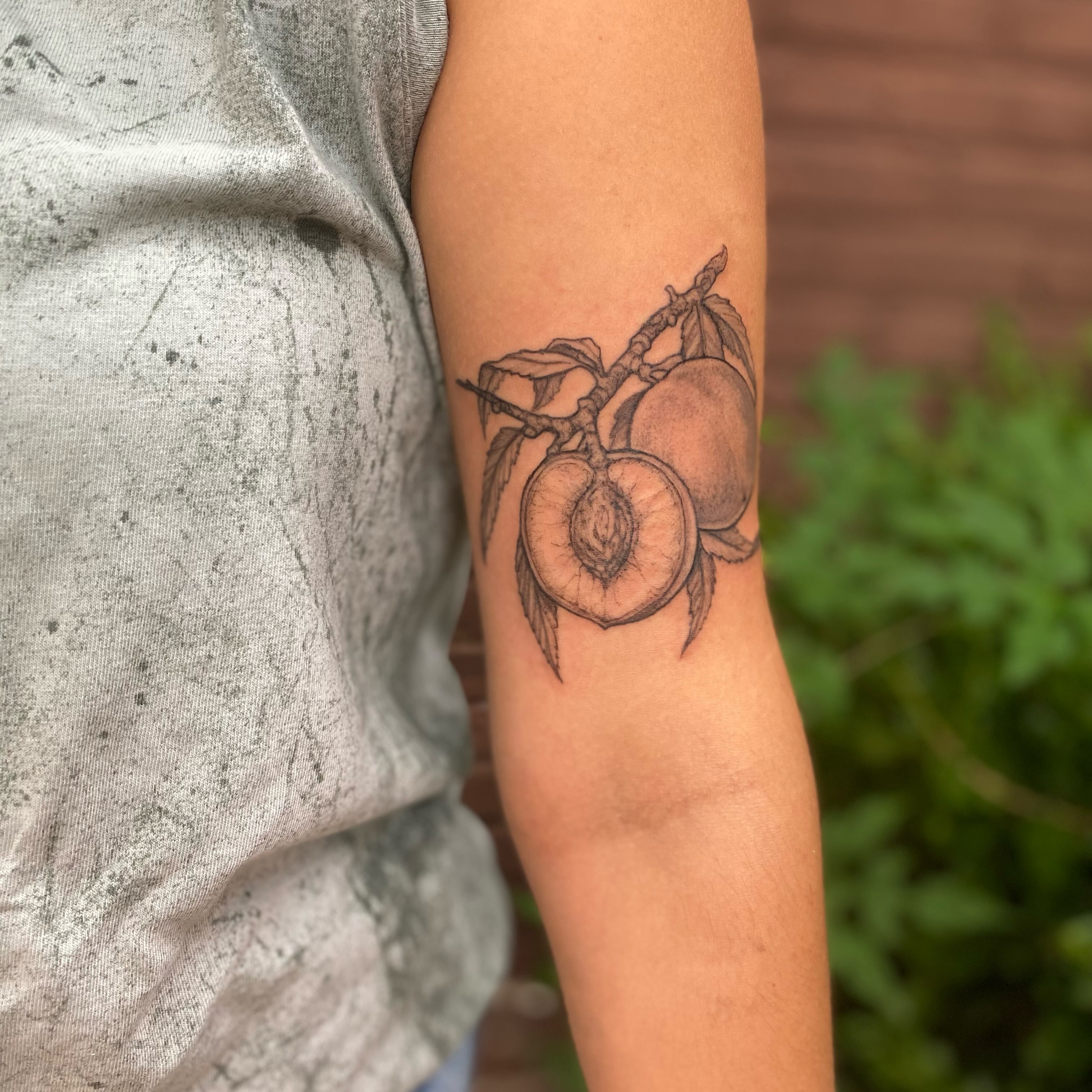 Peaches black and grey tattoo on the forearm by Dana Jones
