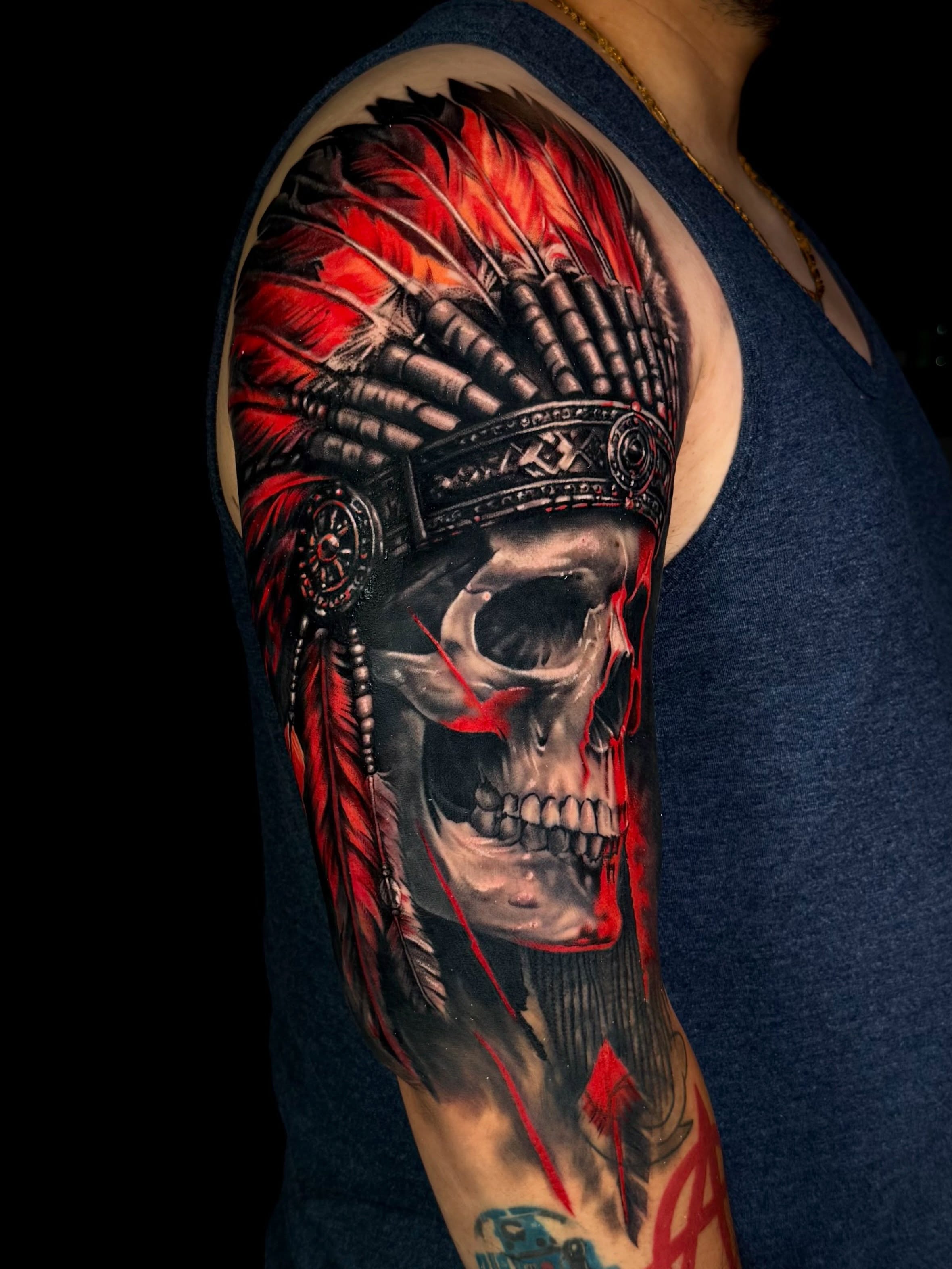Skull wearing headdress realism tattoo on the shoulder by Leah Ross