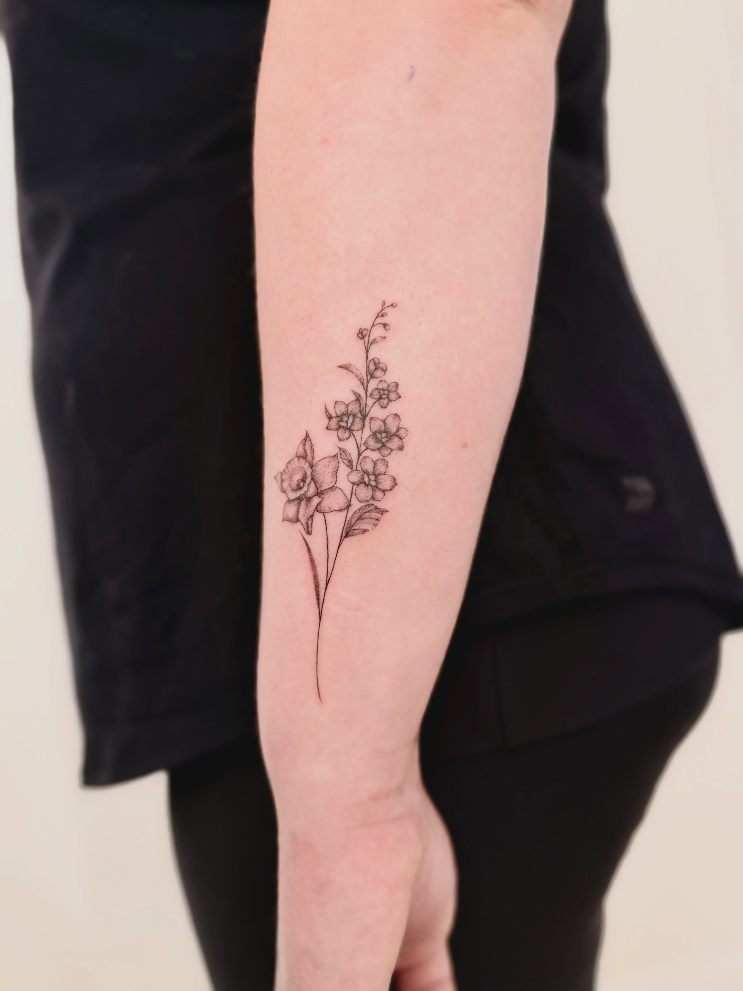 Floral arrangement fine line tattoo on the forearm by Fine Line Tattoo Artist