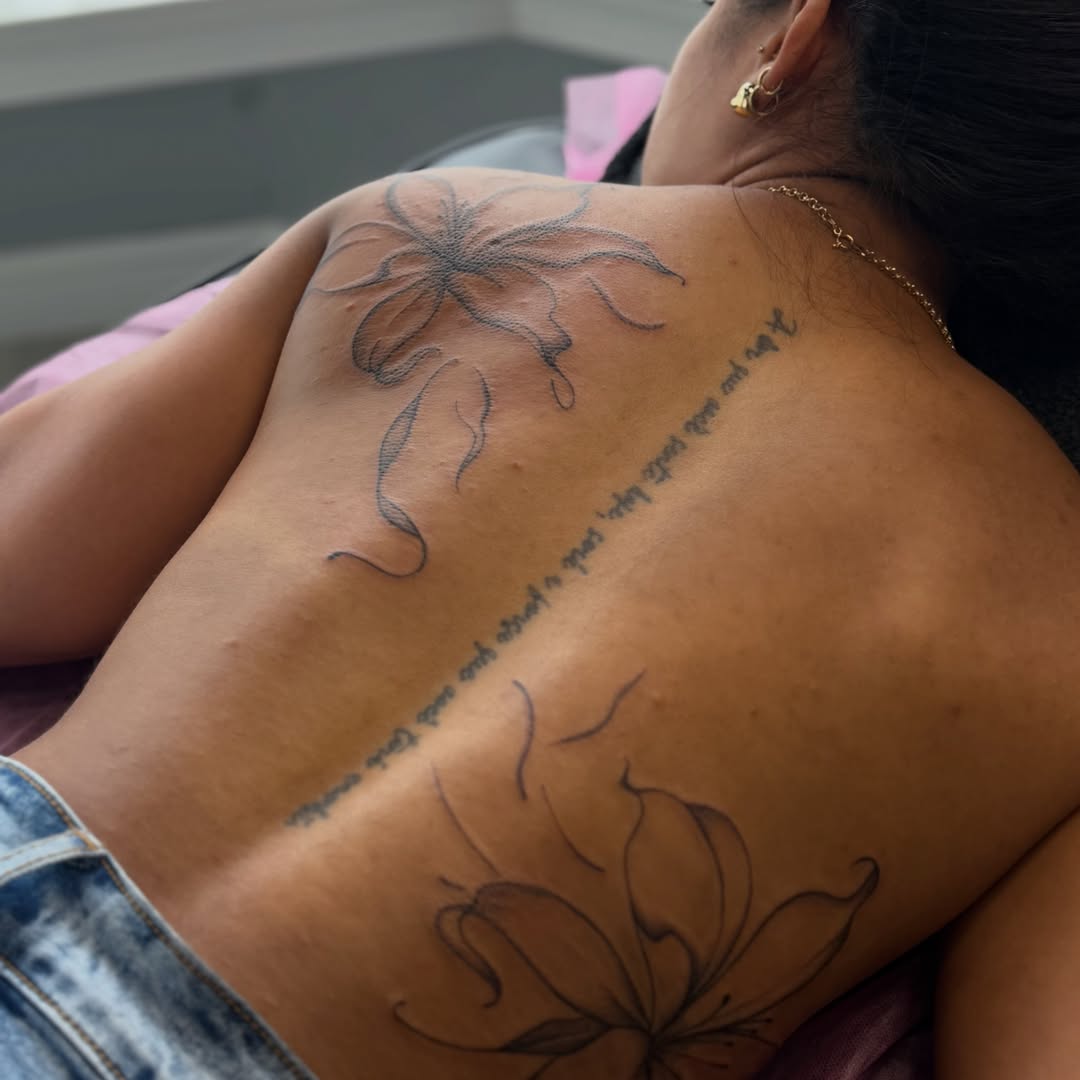 Flower and script black and grey tattoo on the back by Silva Wellen