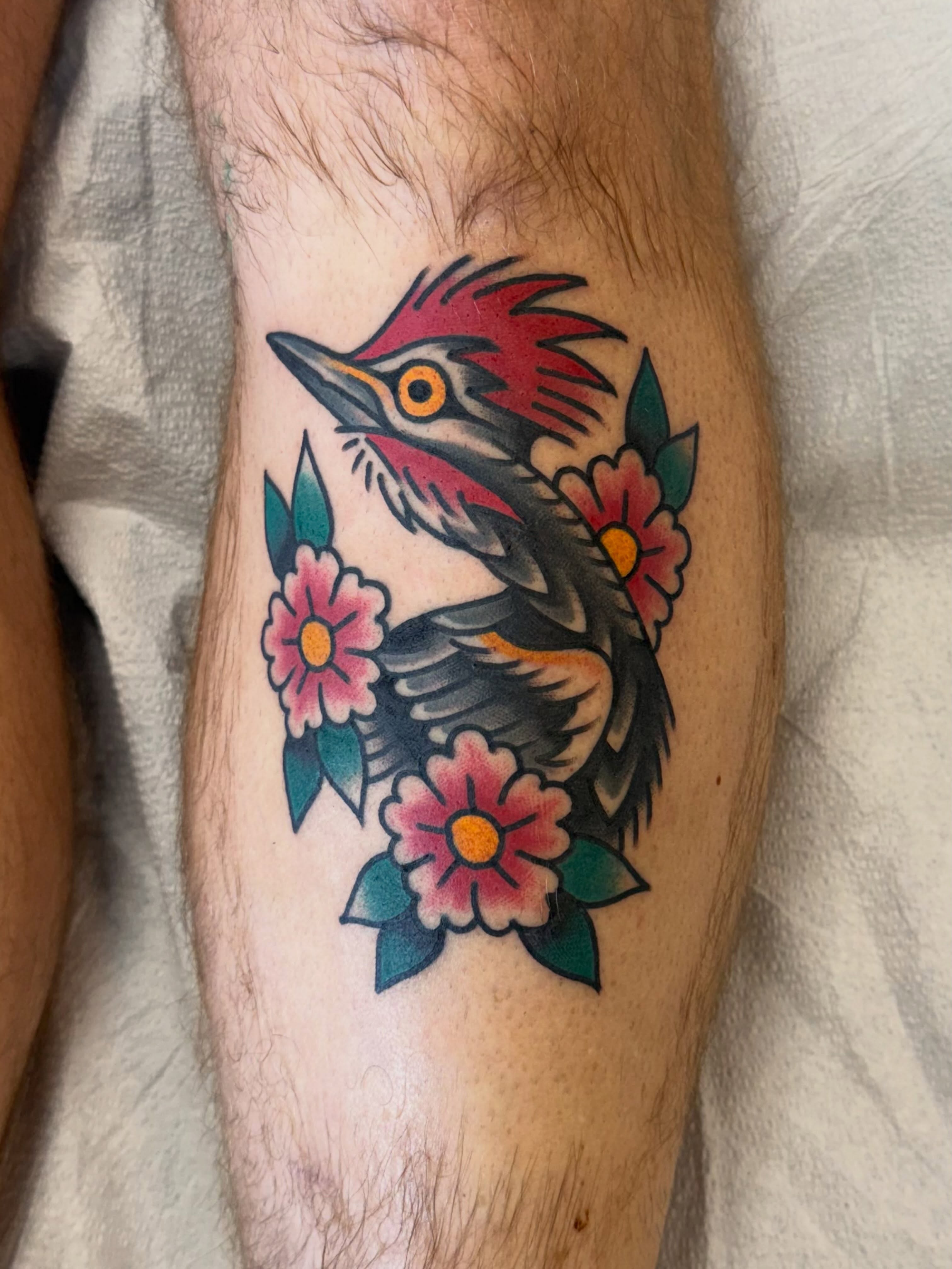 Woodpecker and flowers American traditional tattoo on the forearm by Matt Paw