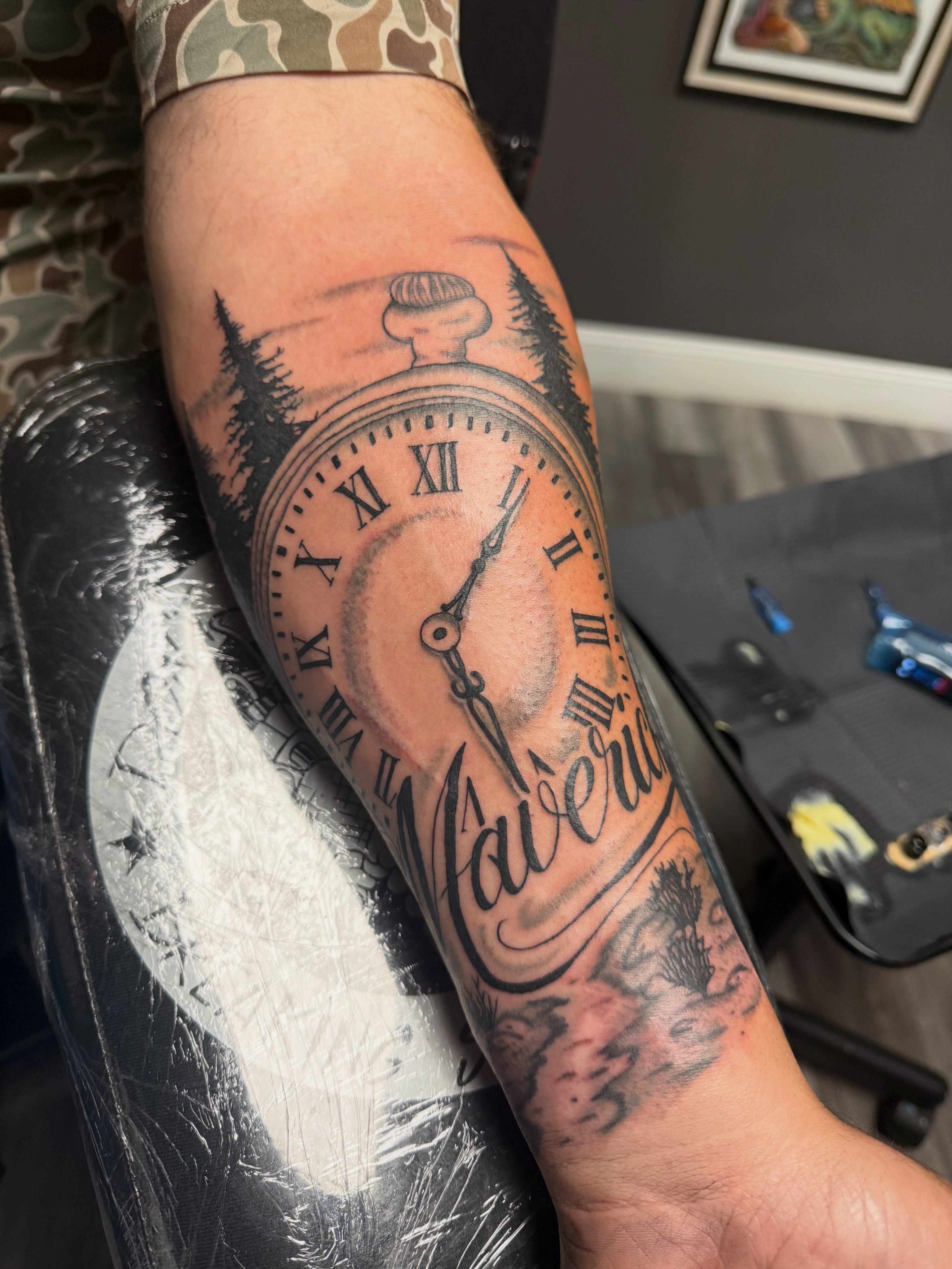 Clock and forest realism tattoo on the forearm by Justin George