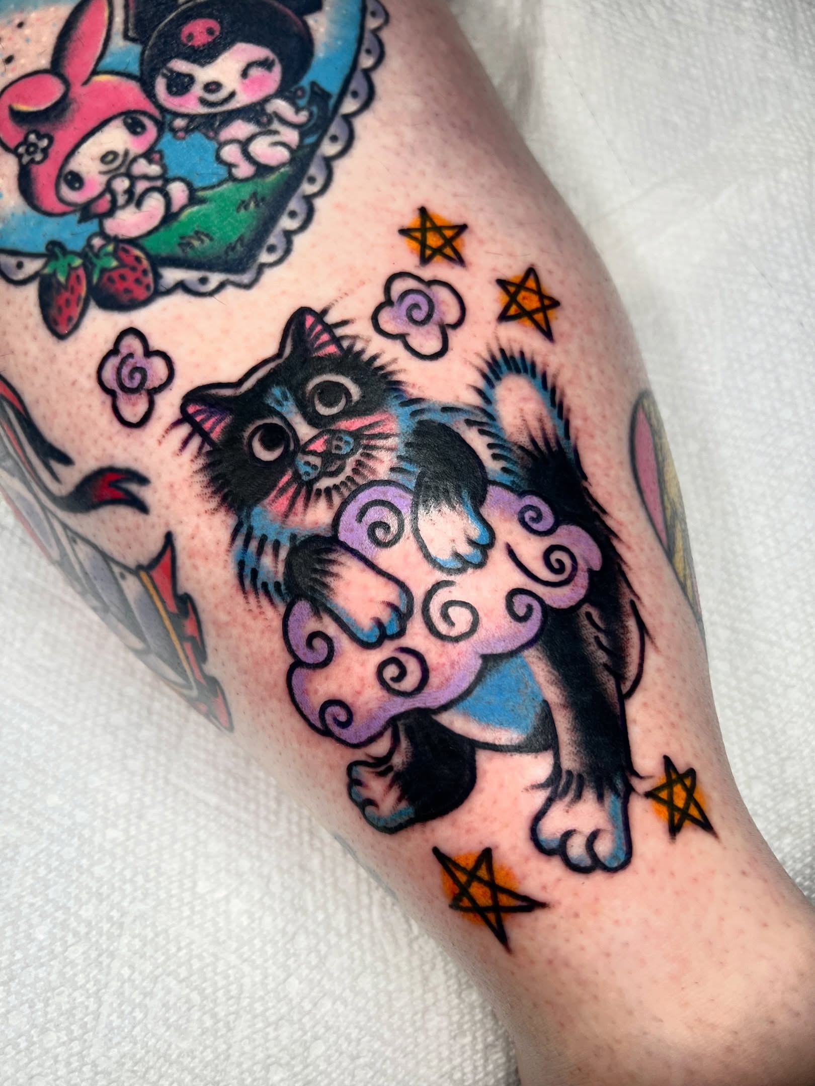Cat and cloud American traditional tattoo on the forearm by Sierra Mack
