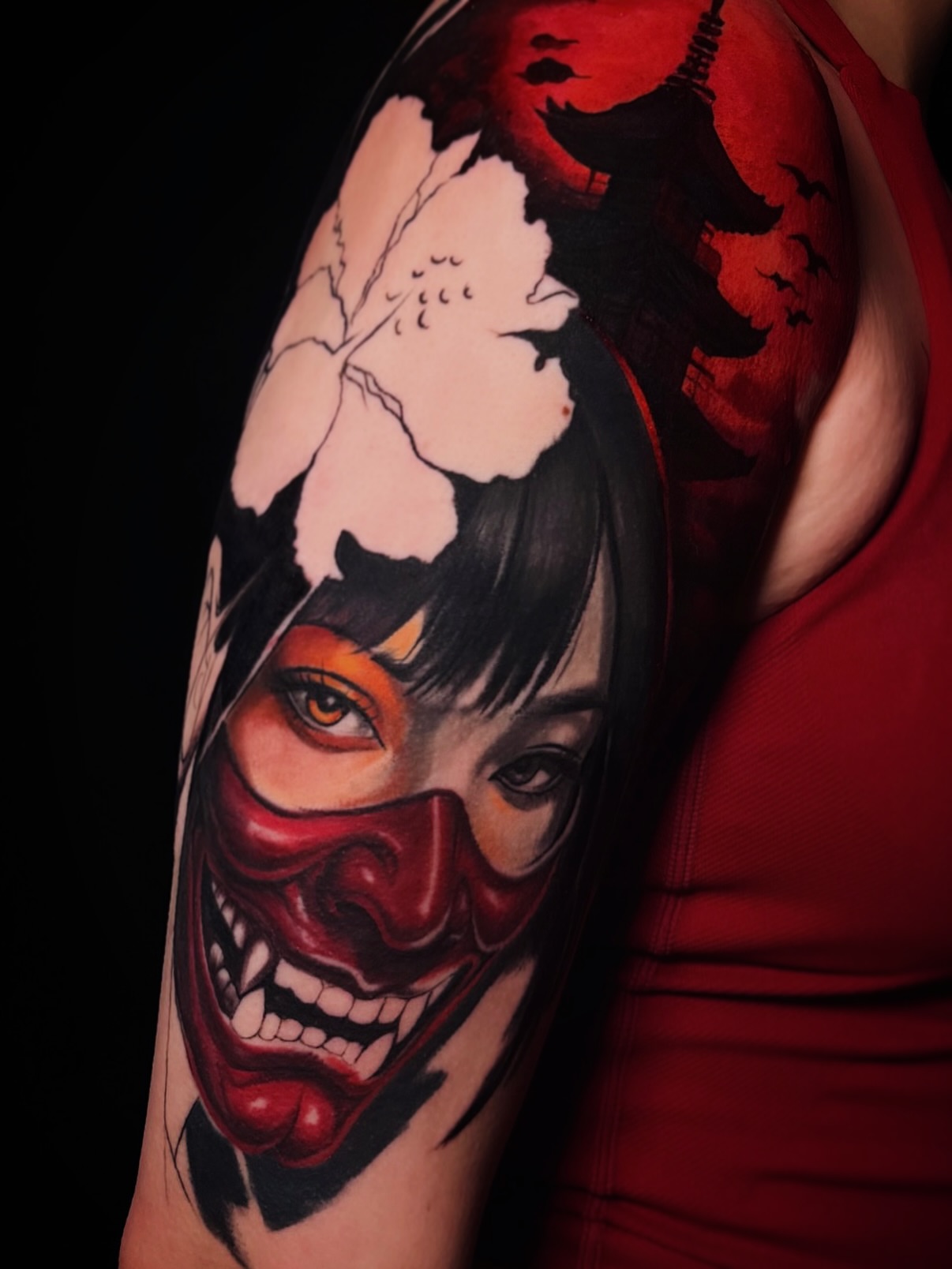 Clown mask dark realism tattoo on the upper arm by ✨ Tattoo Artist
