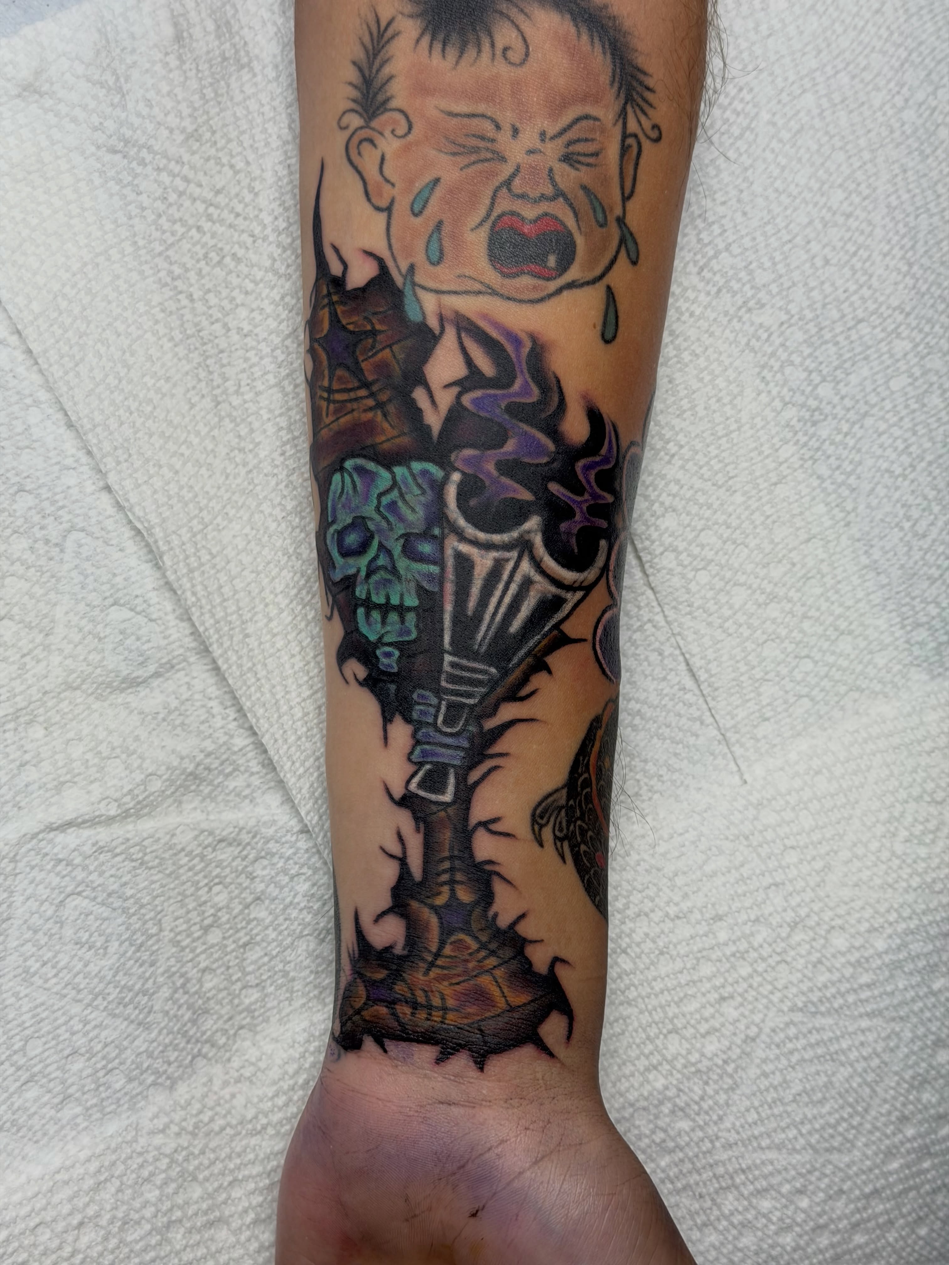 Crying baby American traditional tattoo on the forearm by Squid