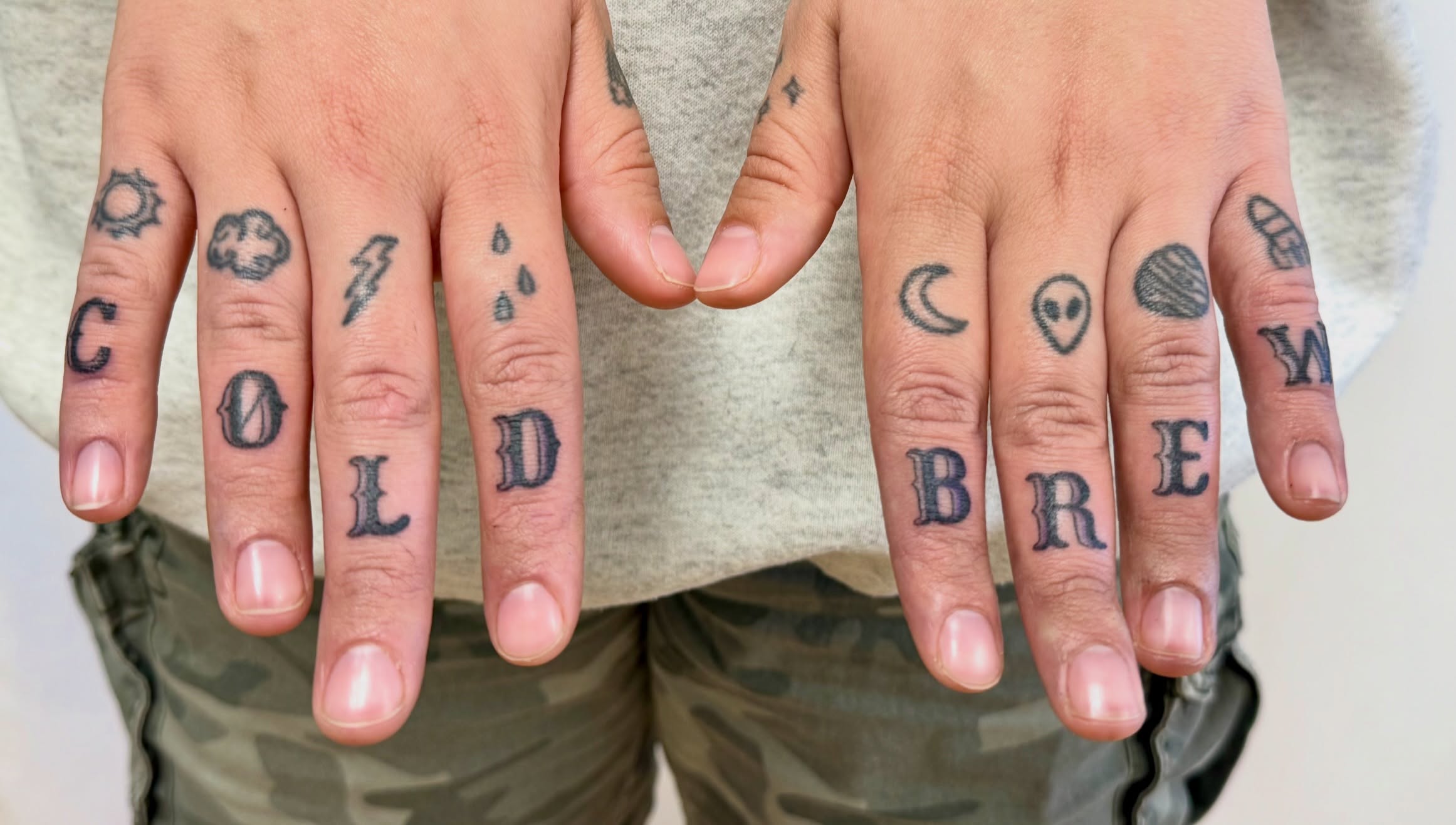 Word 'COOL BREW' lettering script tattoo on the hand by Melia Mariko