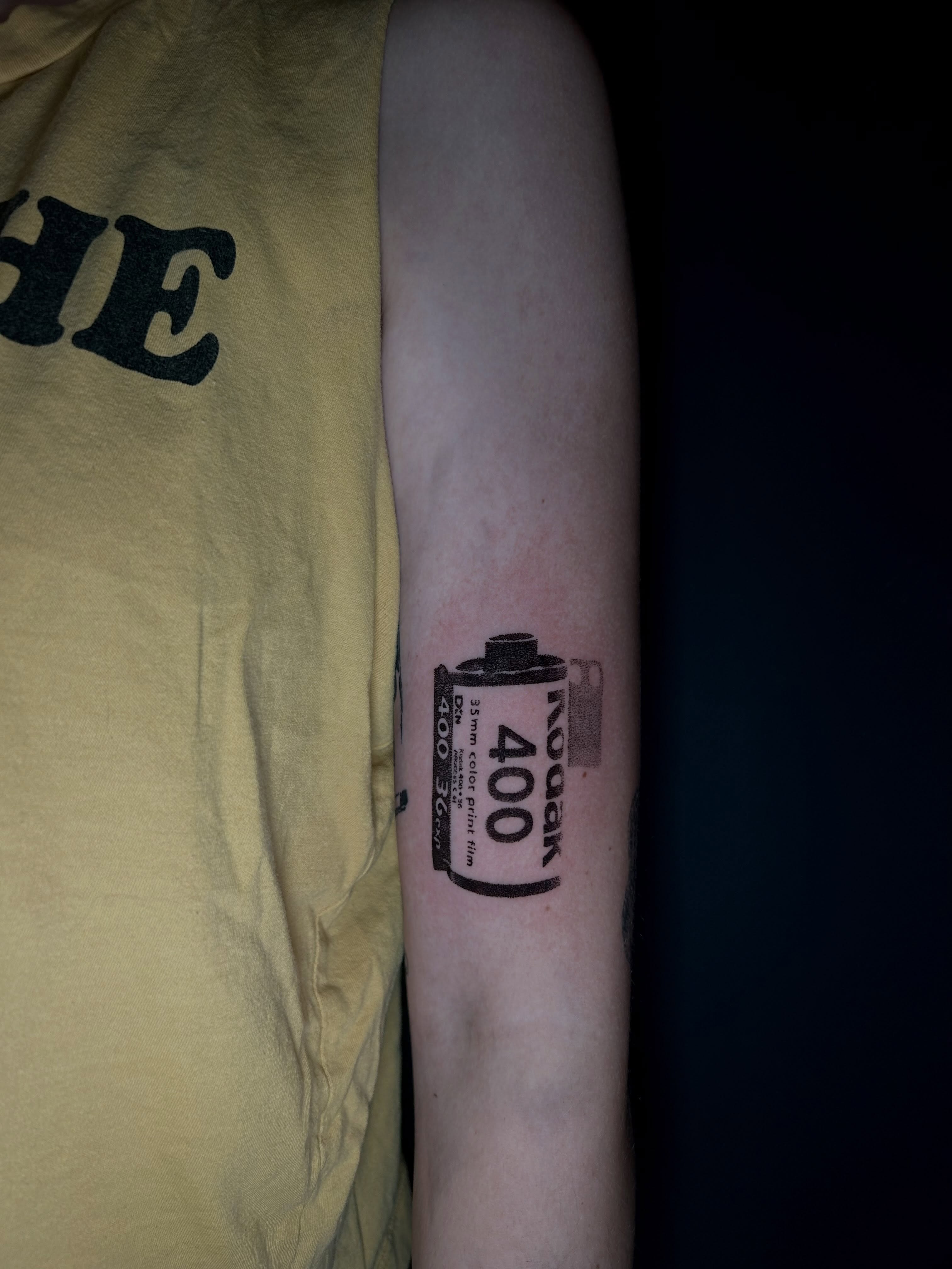 Film roll black and grey tattoo on the forearm by KB