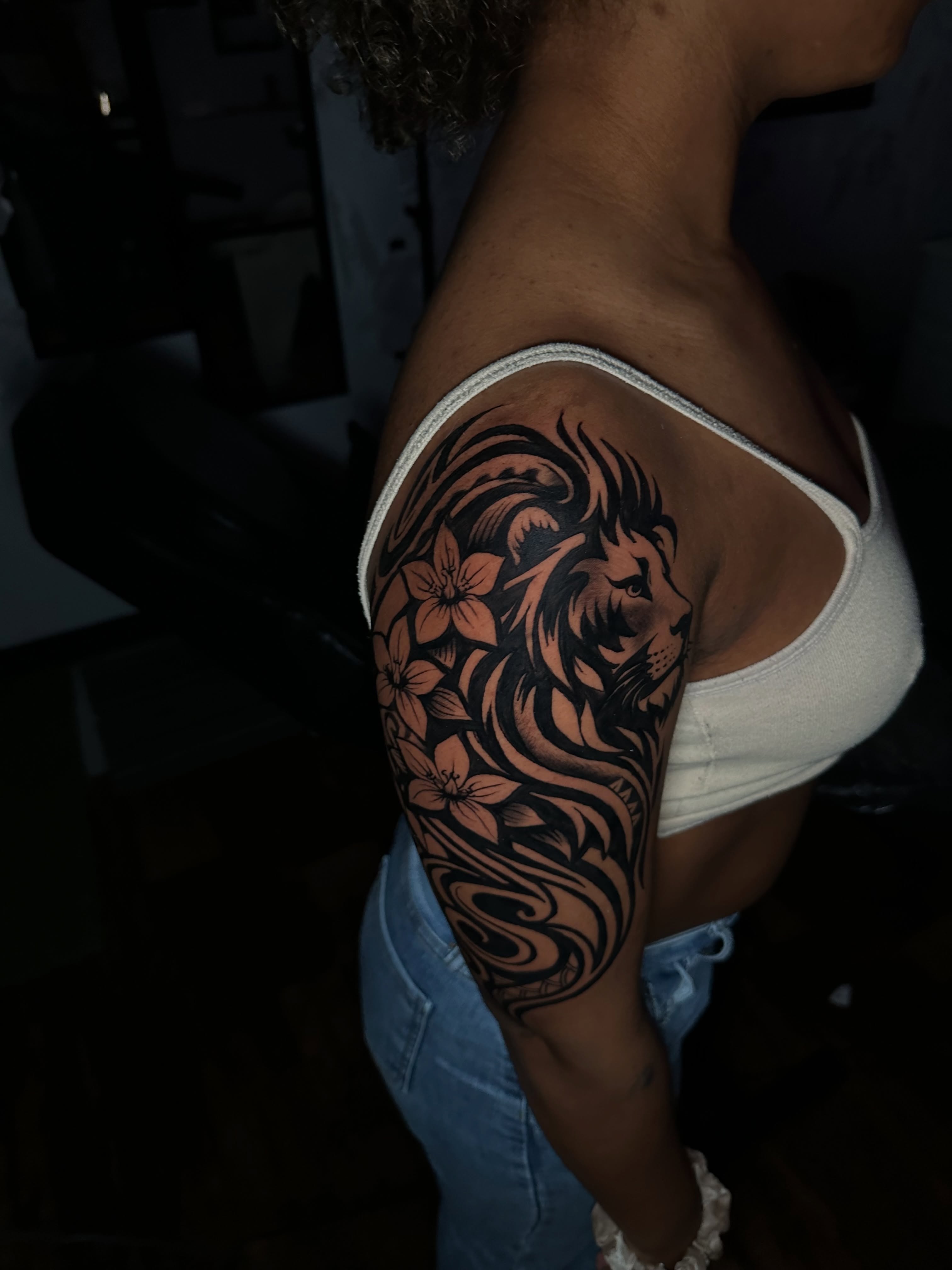 Lion and flowers tribal tattoo on the upper arm by Chris (Pikasso)