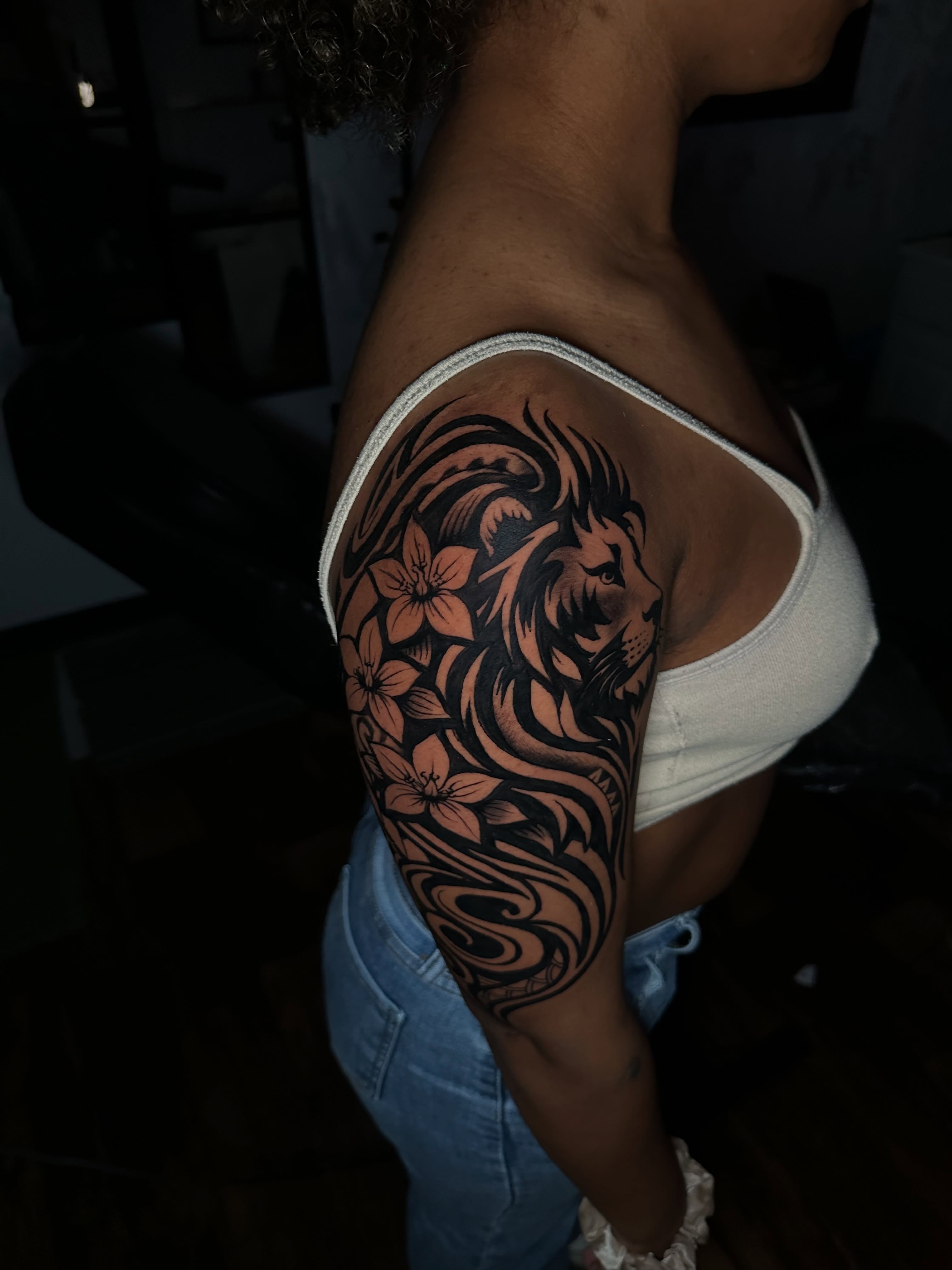 Lion and flowers tribal tattoo on the upper arm by Chris (Pikasso)