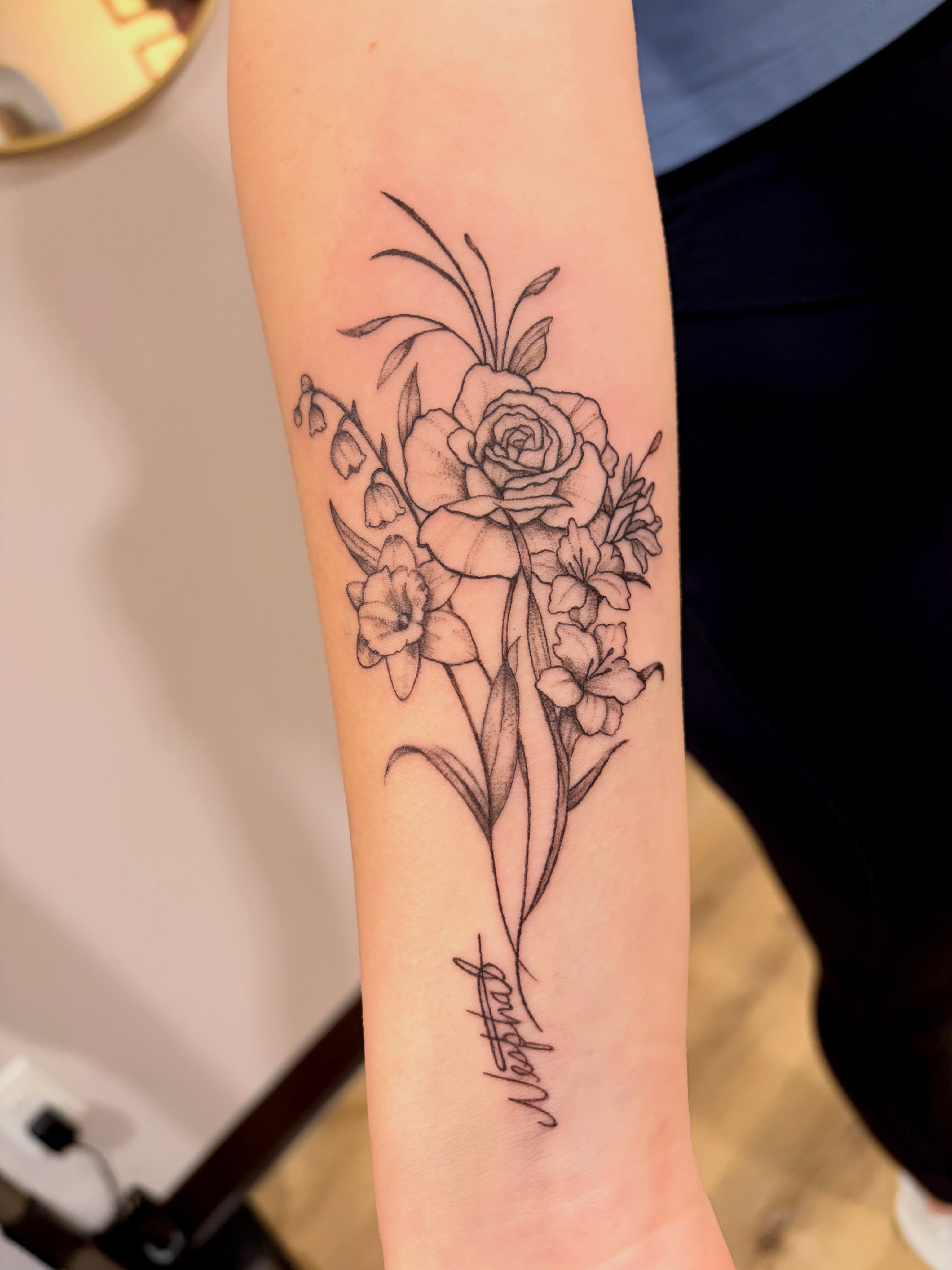 Floral bouquet black and grey tattoo on the forearm by Emily, Monticello, Iowa