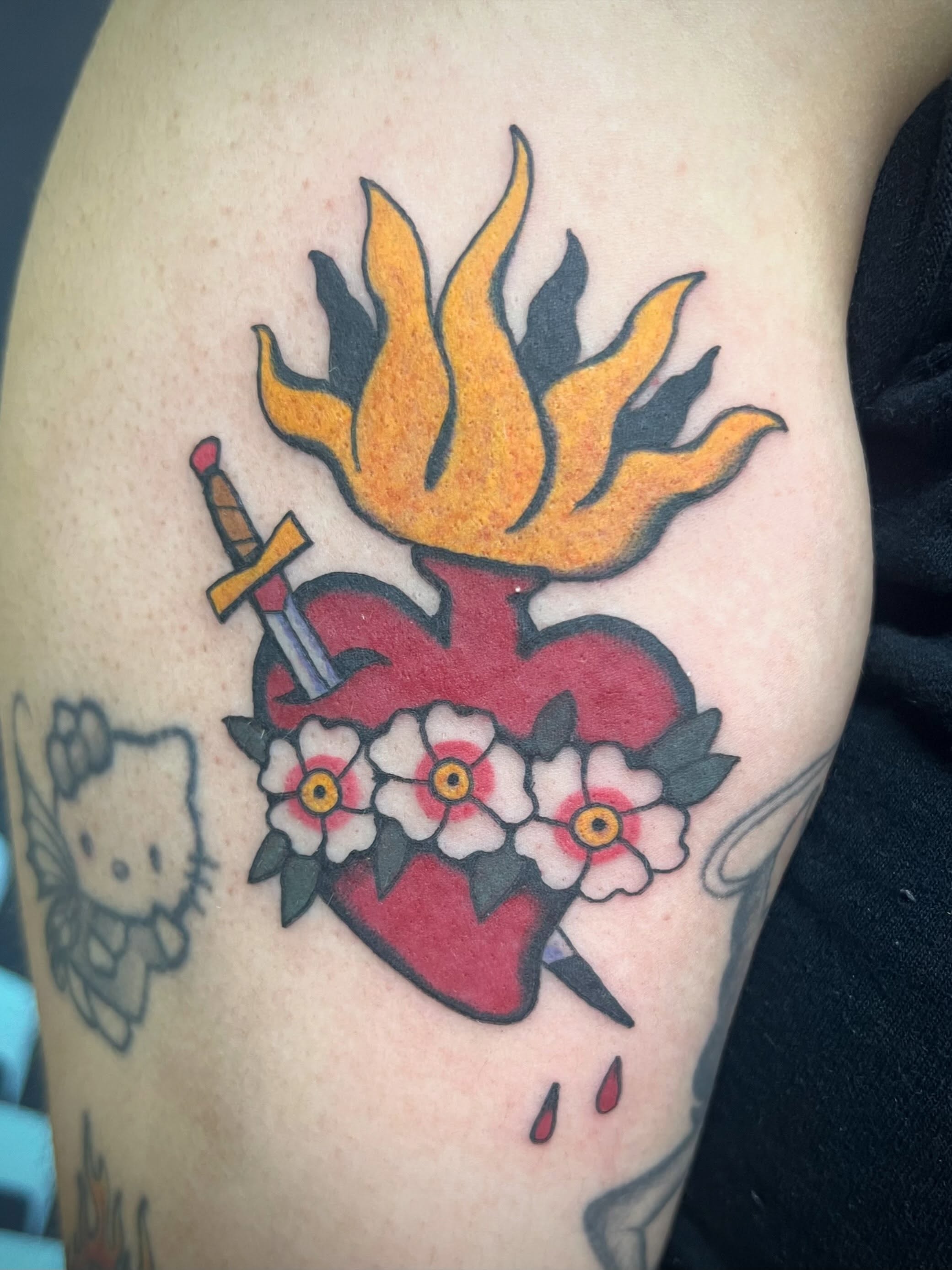 Flaming heart with flowers American traditional tattoo on the shoulder by Natalie Phillips, Oakland, California