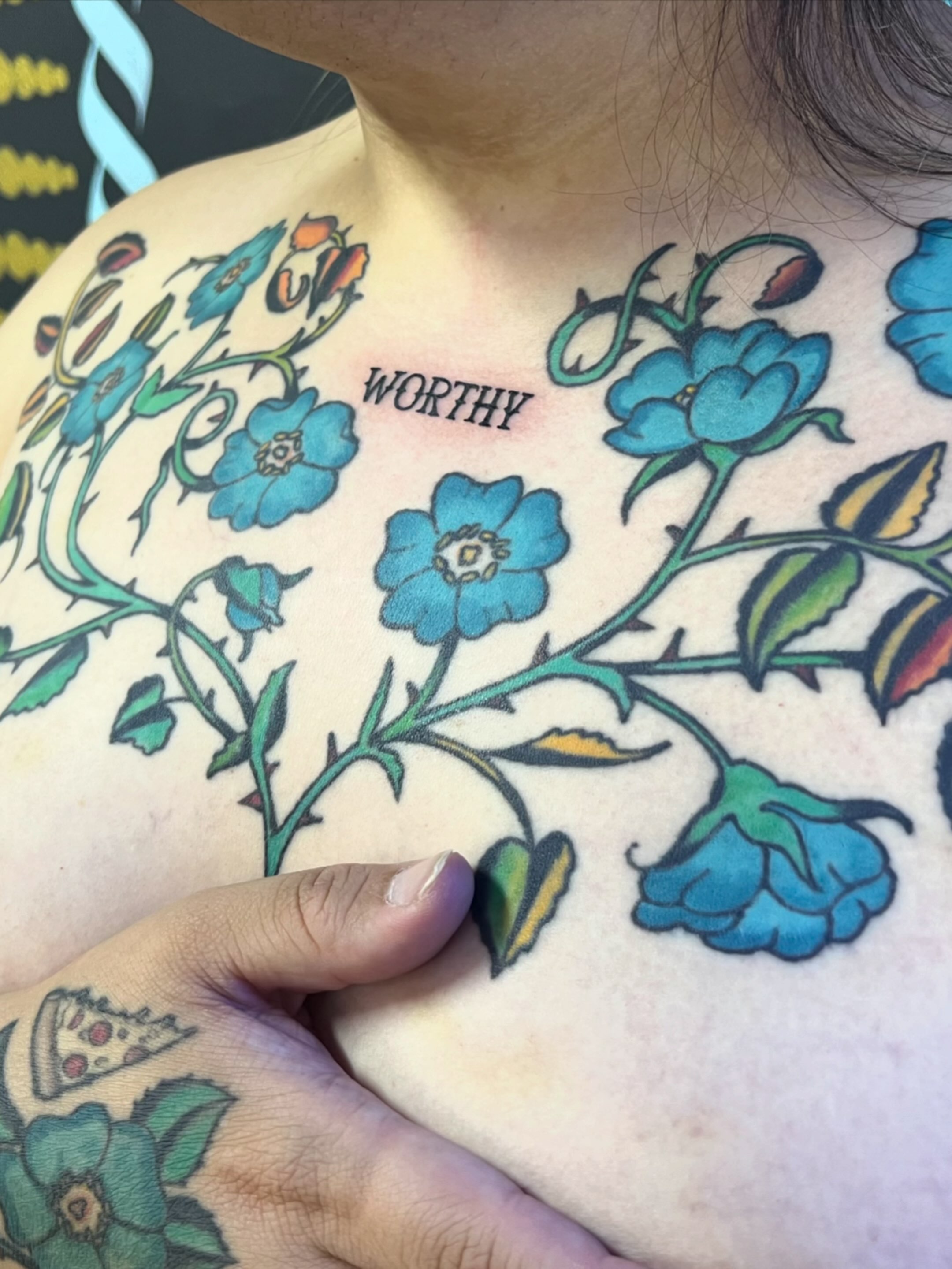 Blue flowers American traditional tattoo on the chest by Natalie Phillips, Oakland, California