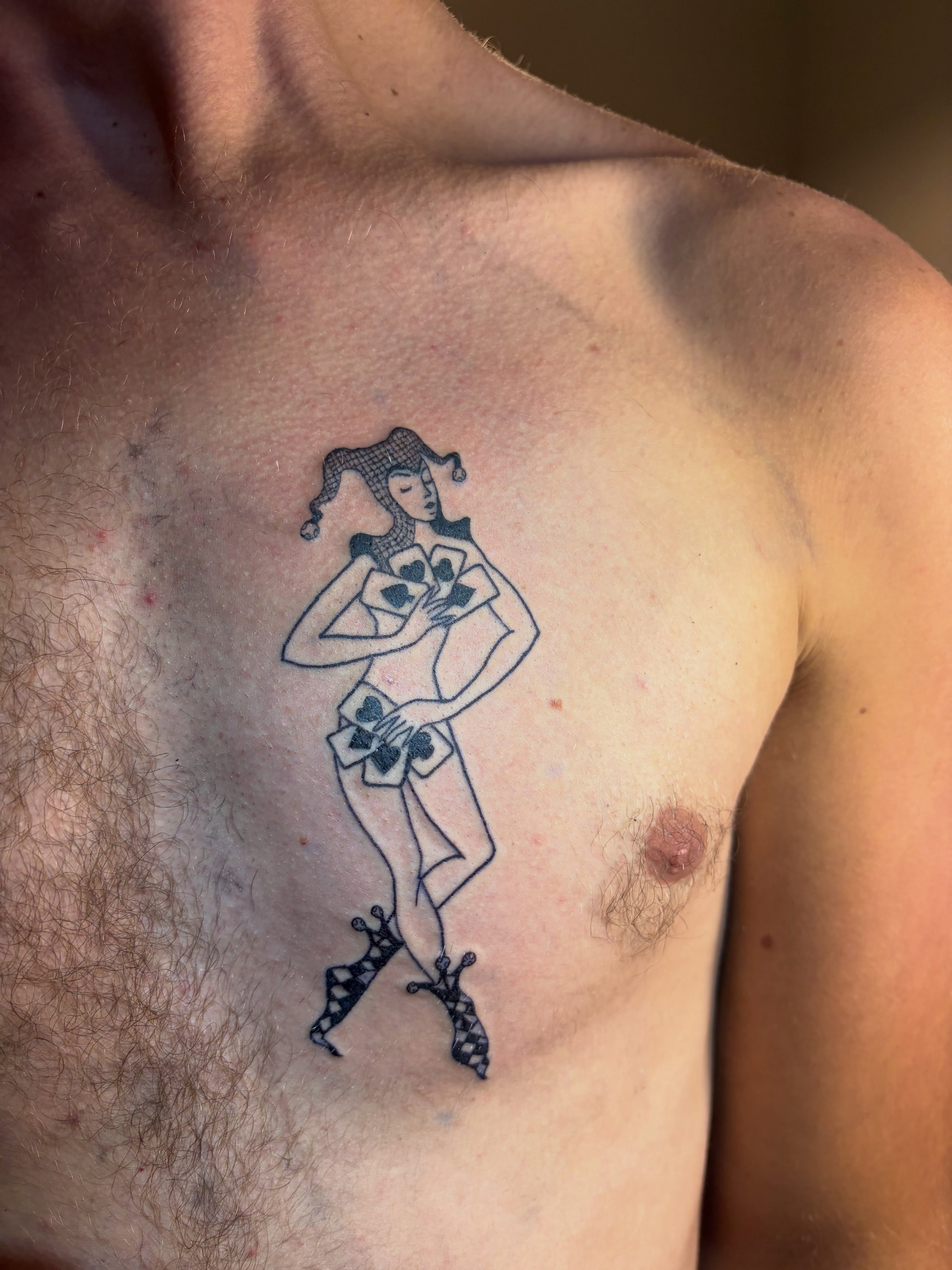 Joker card character black and grey tattoo on the chest by blastedbybk