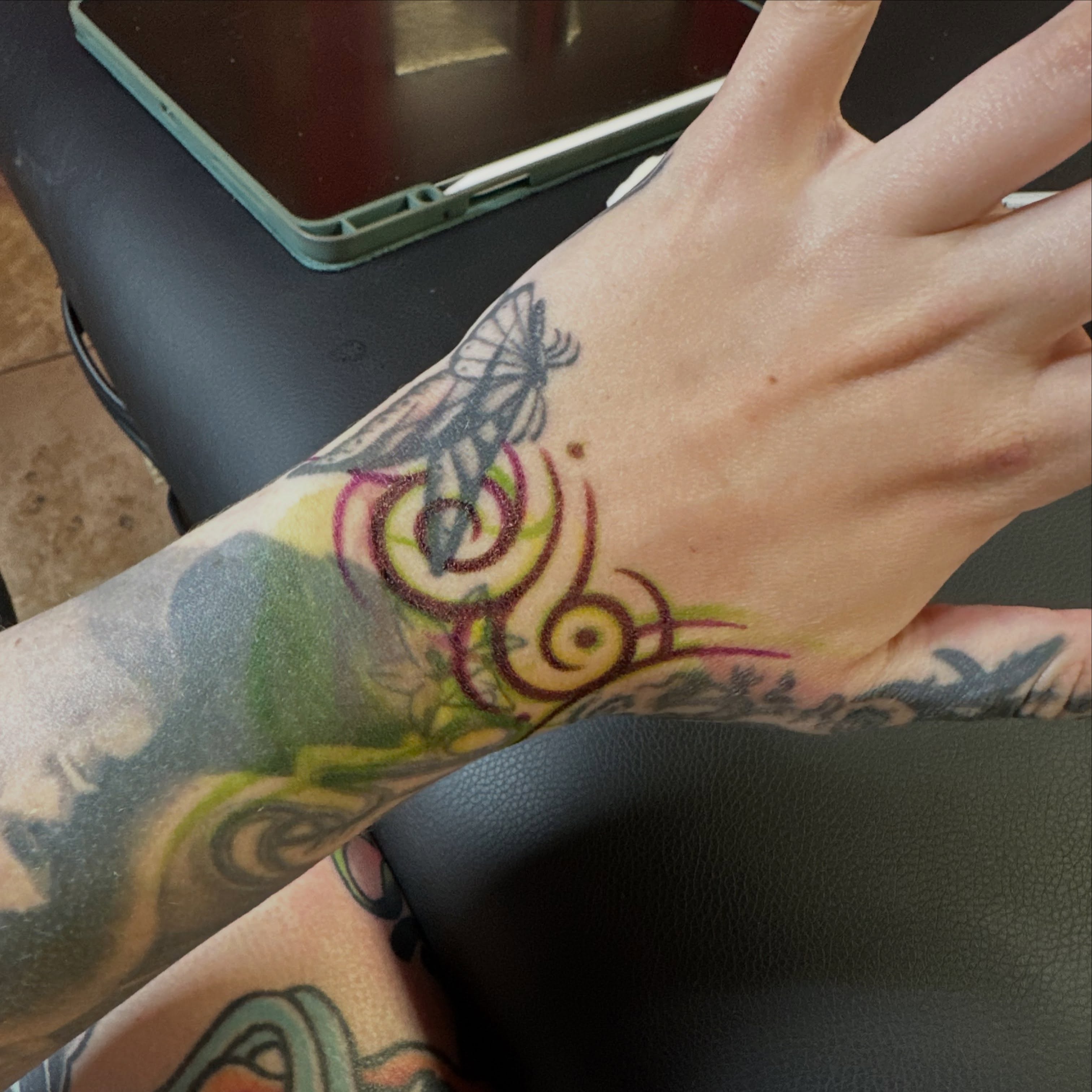 Swirls and dragonfly new school tattoo on the forearm by Alexa Wolfkiel