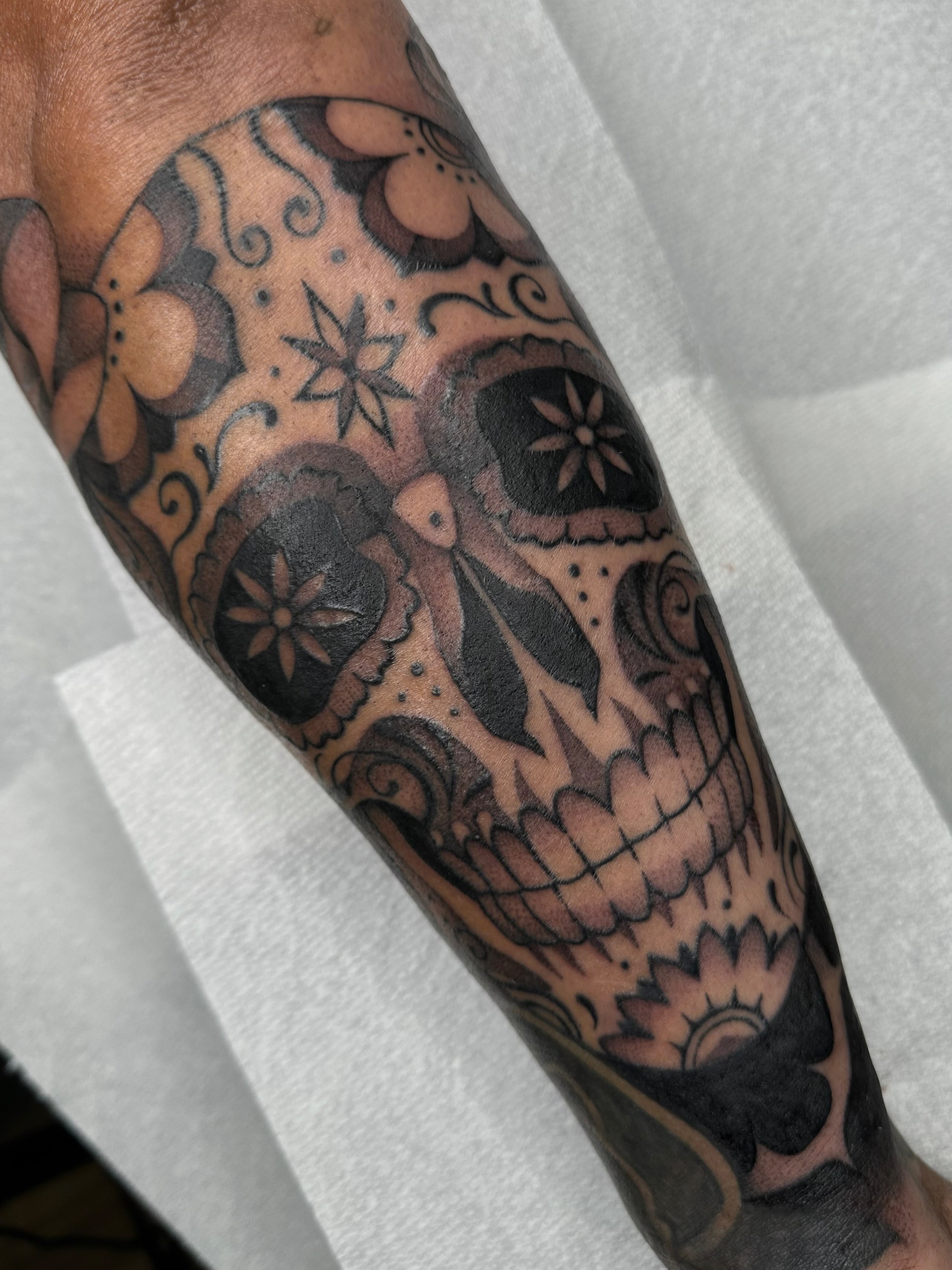 Sugar skull black and grey tattoo on the forearm by Aleksandra
