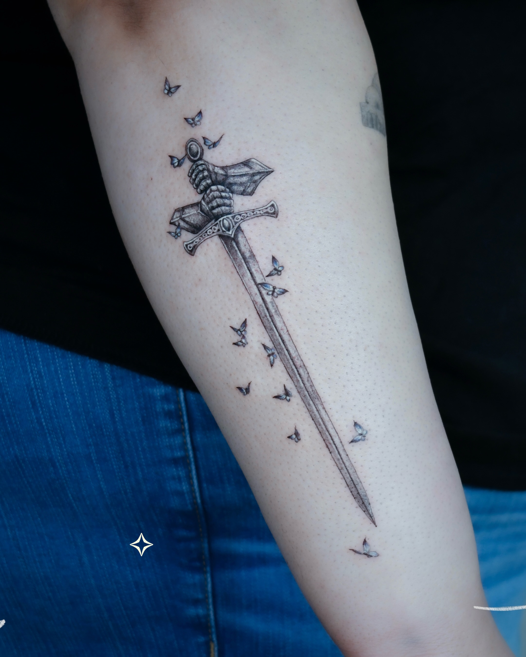 Sword with birds black and grey tattoo on the forearm by 𝐇𝐚𝐫𝐩𝐞𝐫