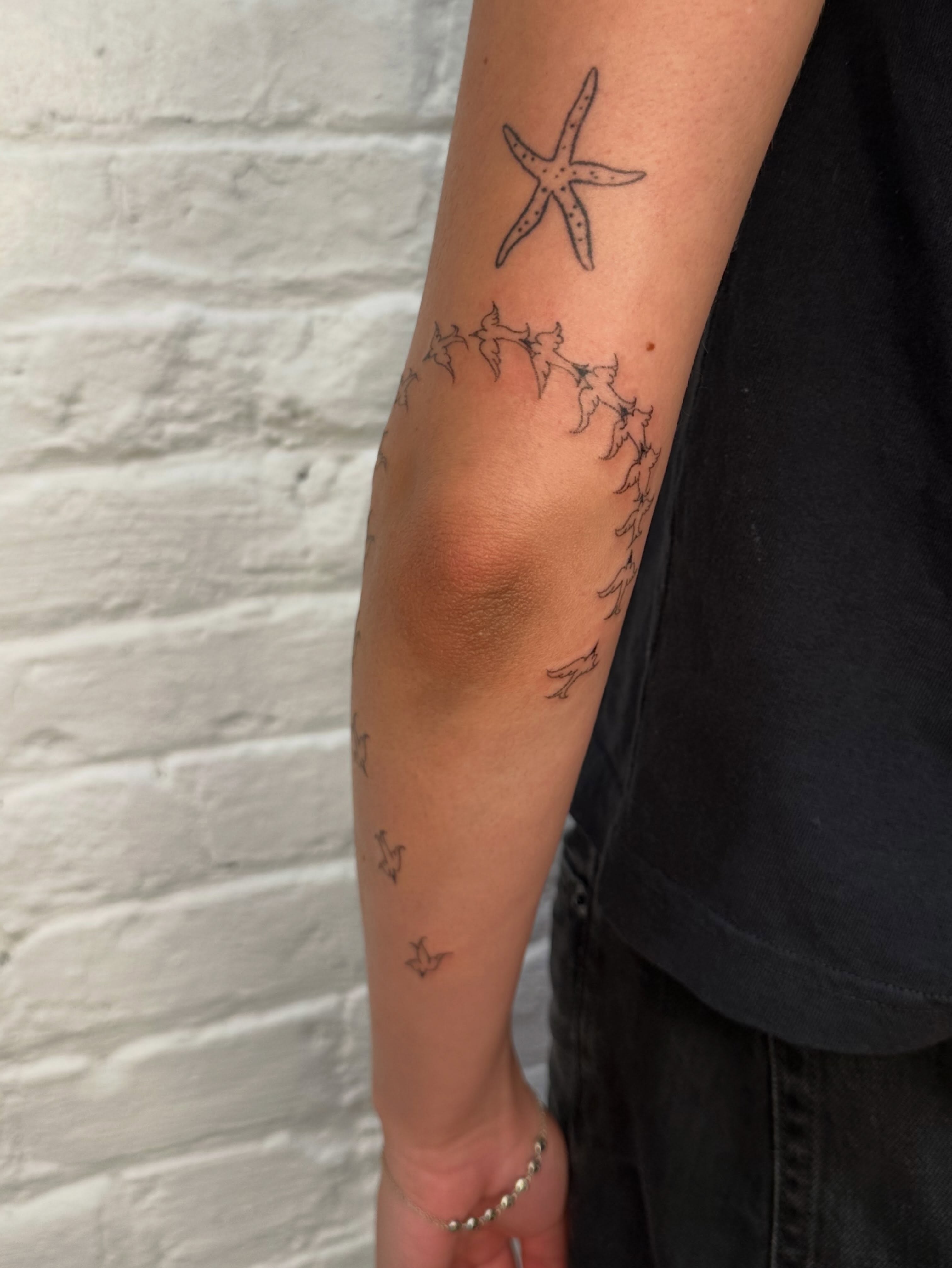 Starfish and thorns black and grey tattoo on the forearm by kate