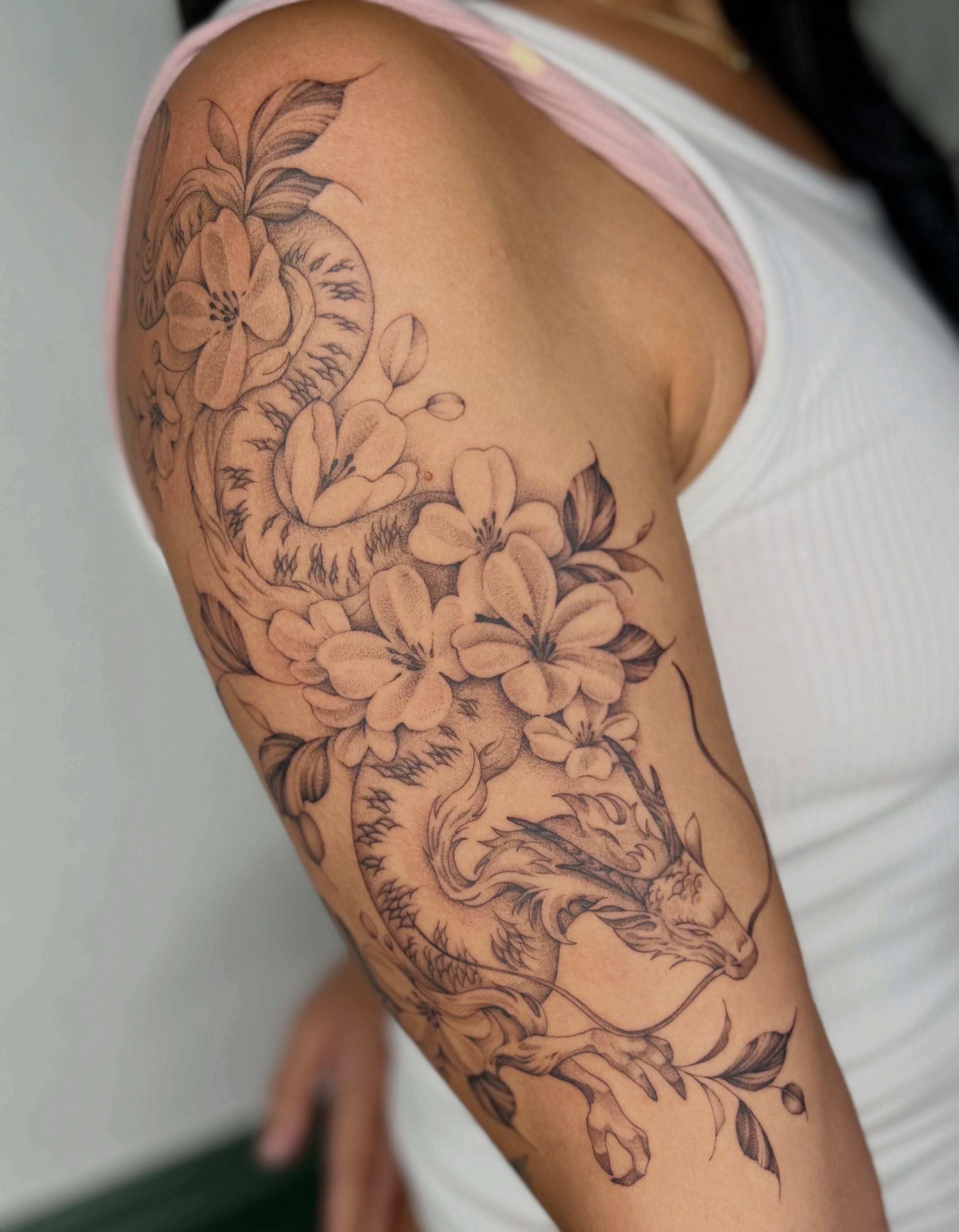 Deer and flowers realism tattoo on the upper arm by Ash F