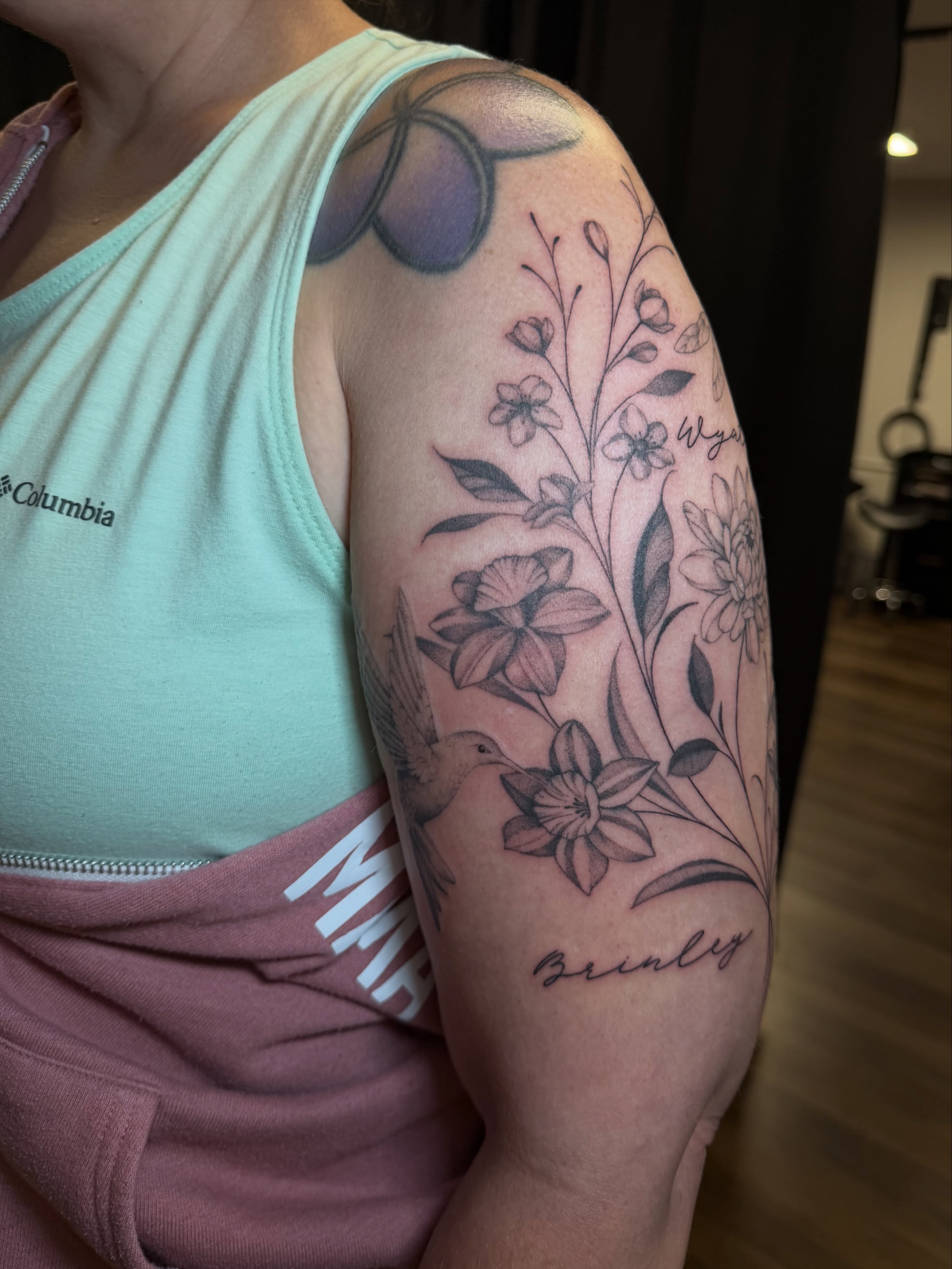 Floral arrangement realism tattoo on the upper arm by Priscilla Michels
