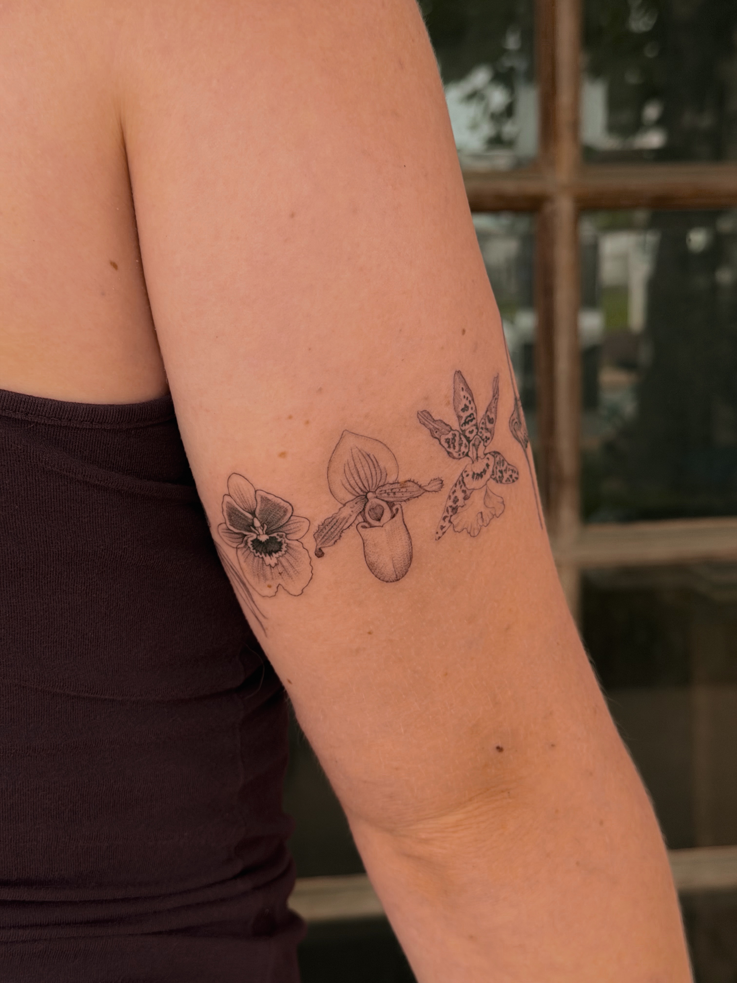 Orchids black and grey tattoo on the forearm by Floral
