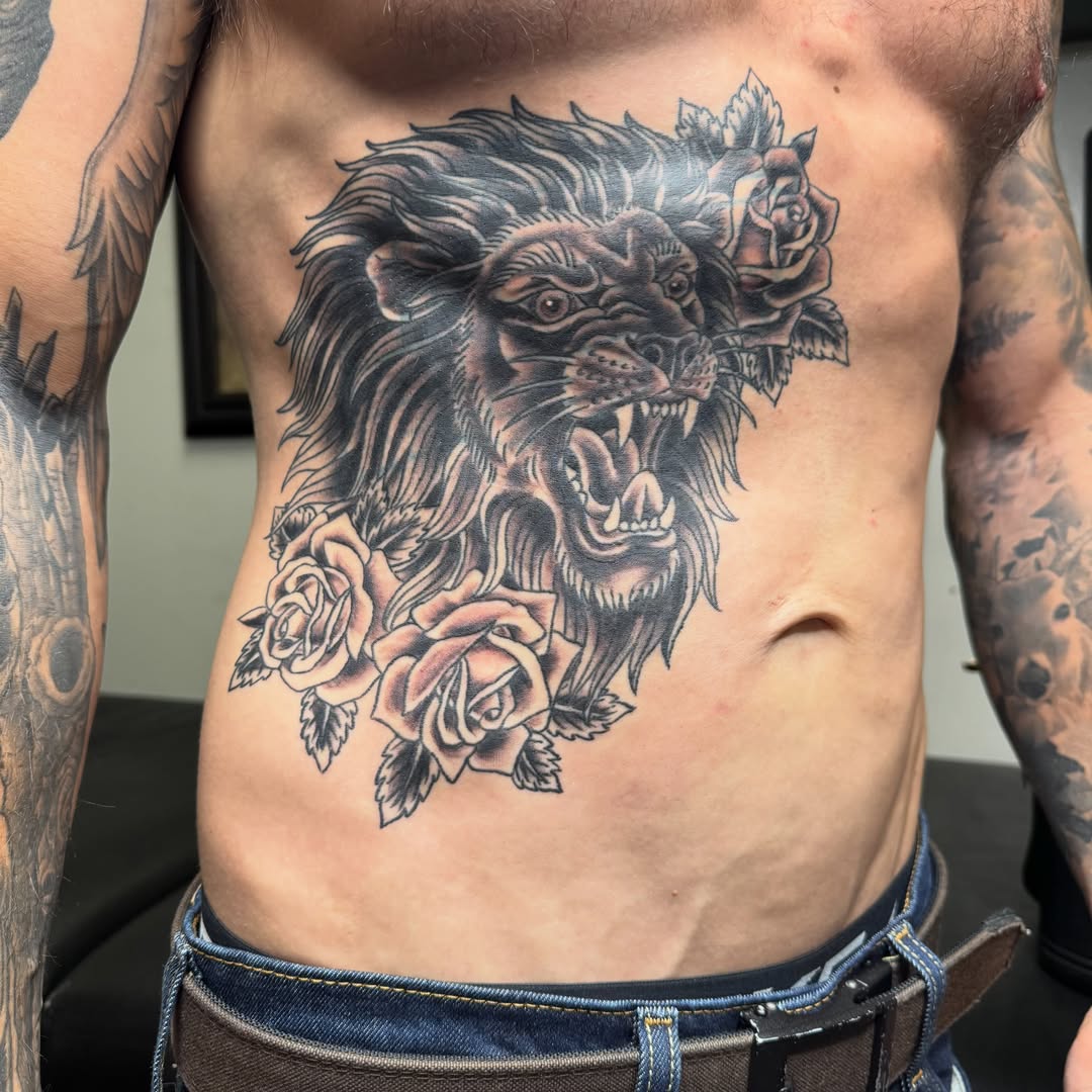 Lion and roses realism tattoo on the chest by Kyle Holt