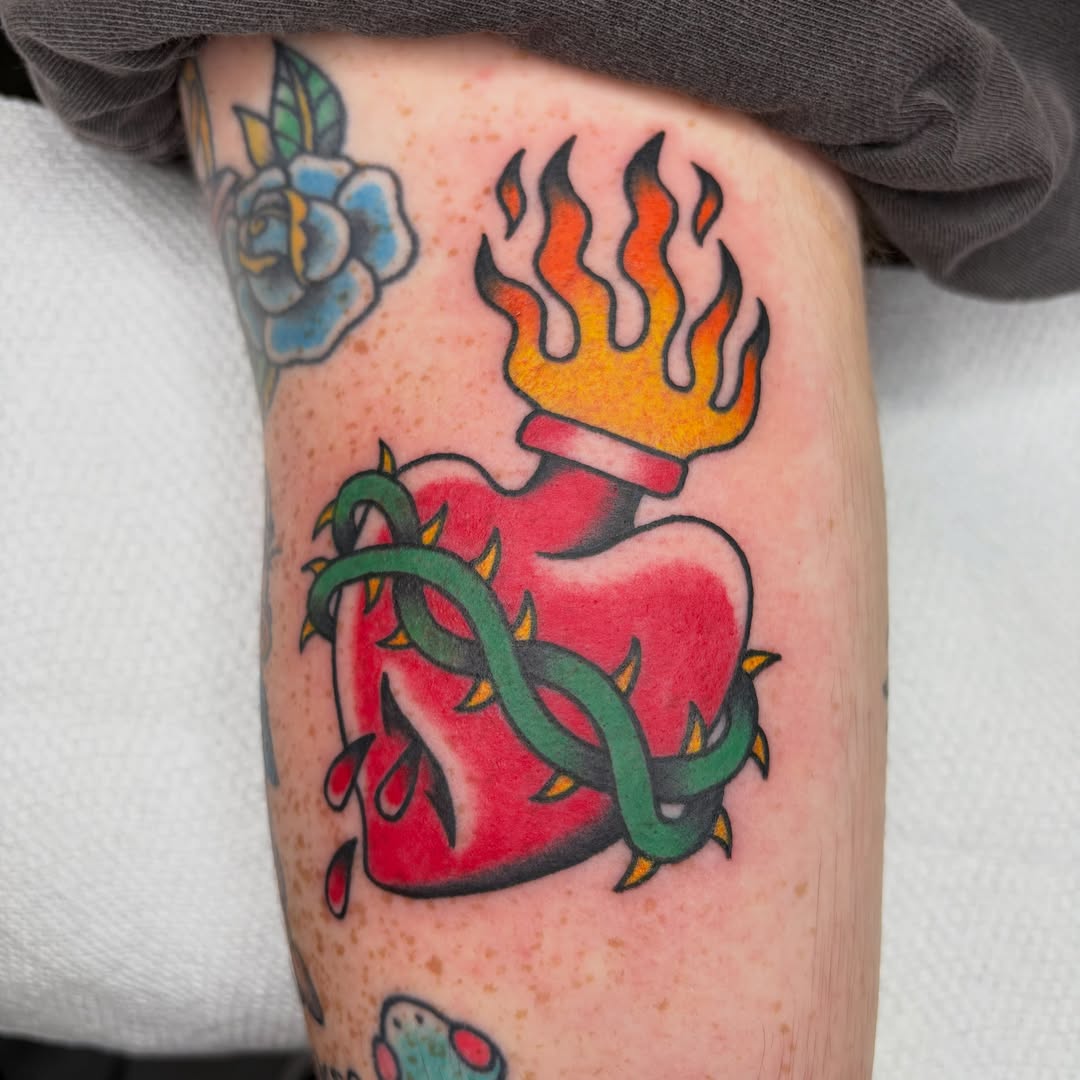 Heart with flames and snake American traditional tattoo on the forearm by Bregan ✨