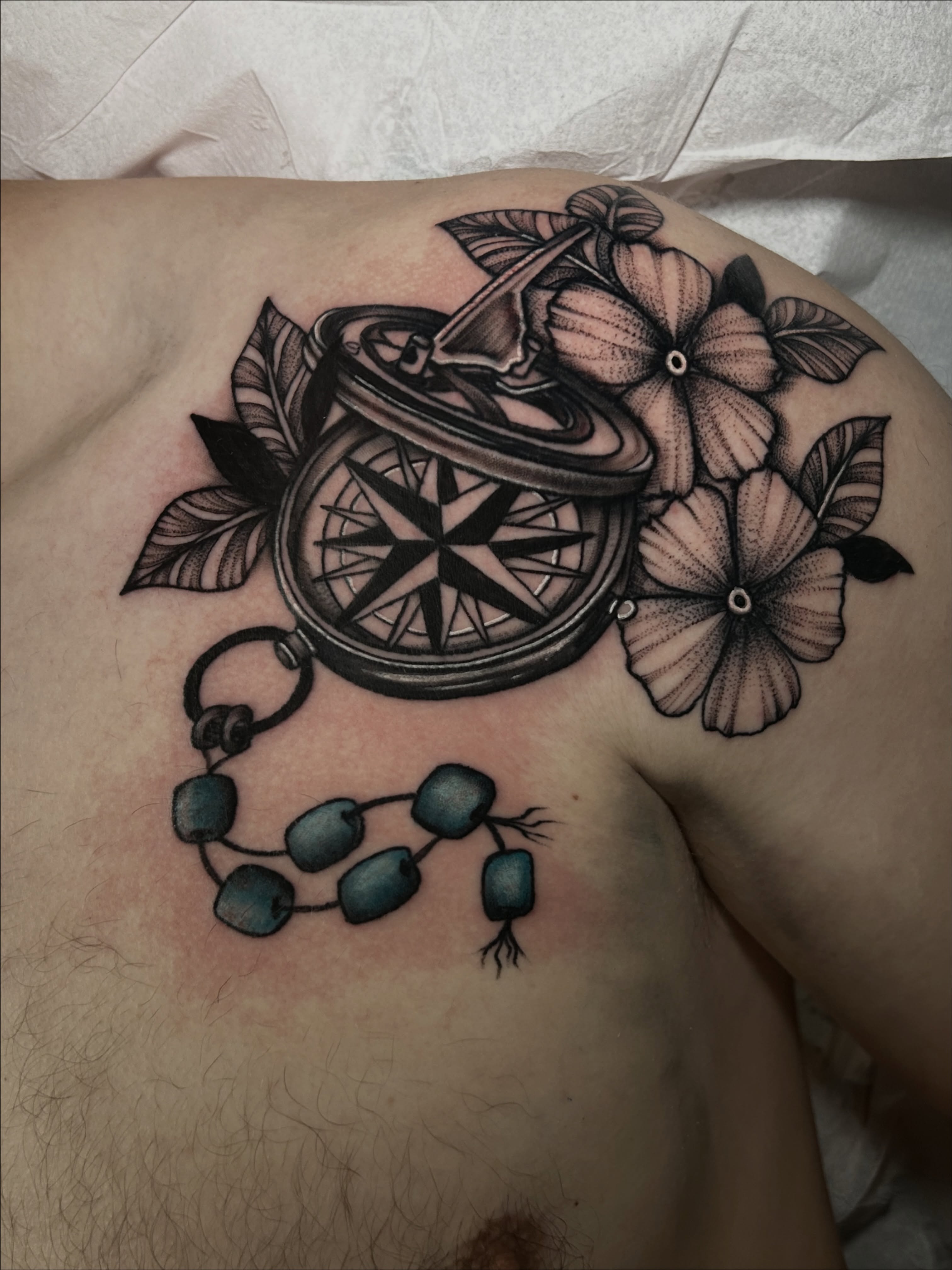 Compass and flowers geometric tattoo on the chest by Kirsten Cameron