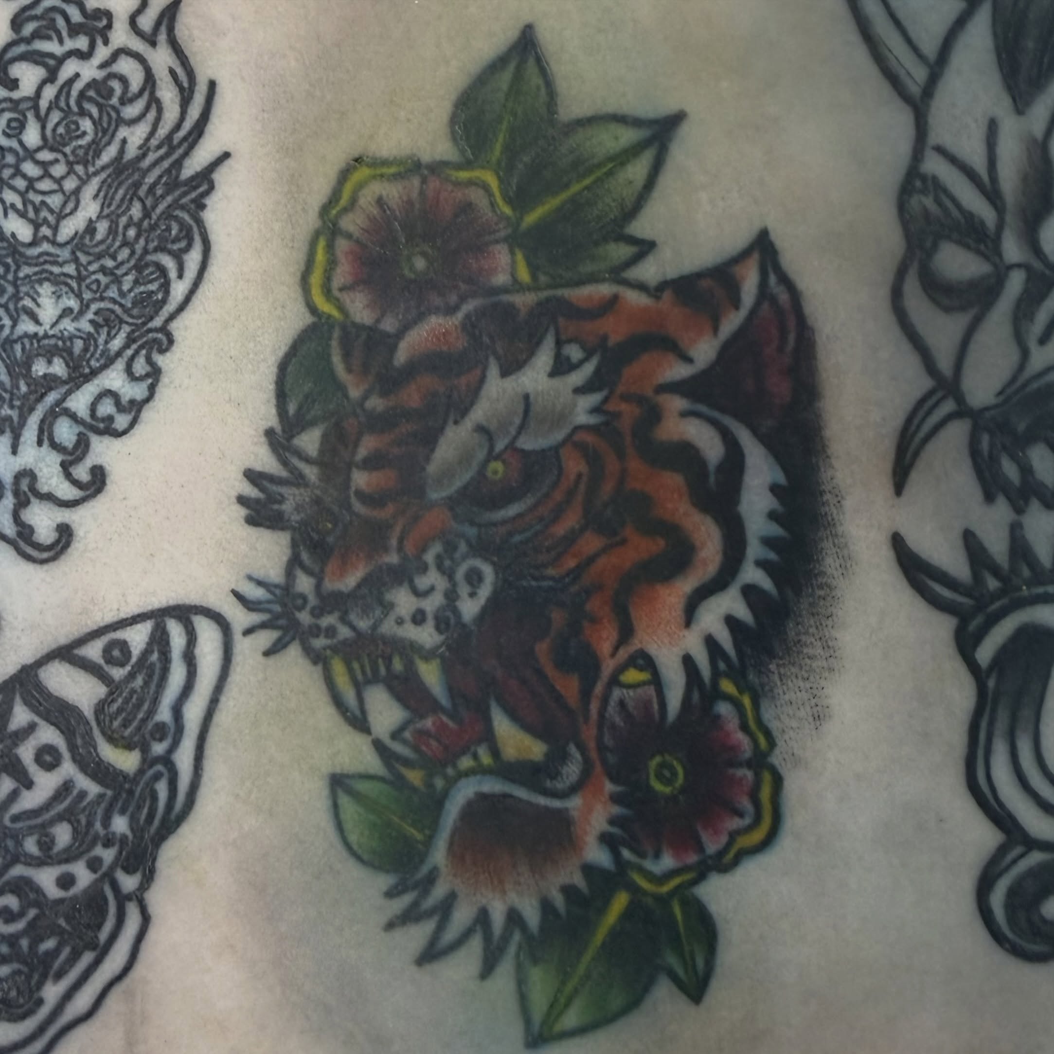 Tiger and flowers American traditional tattoo by Addison Bruce