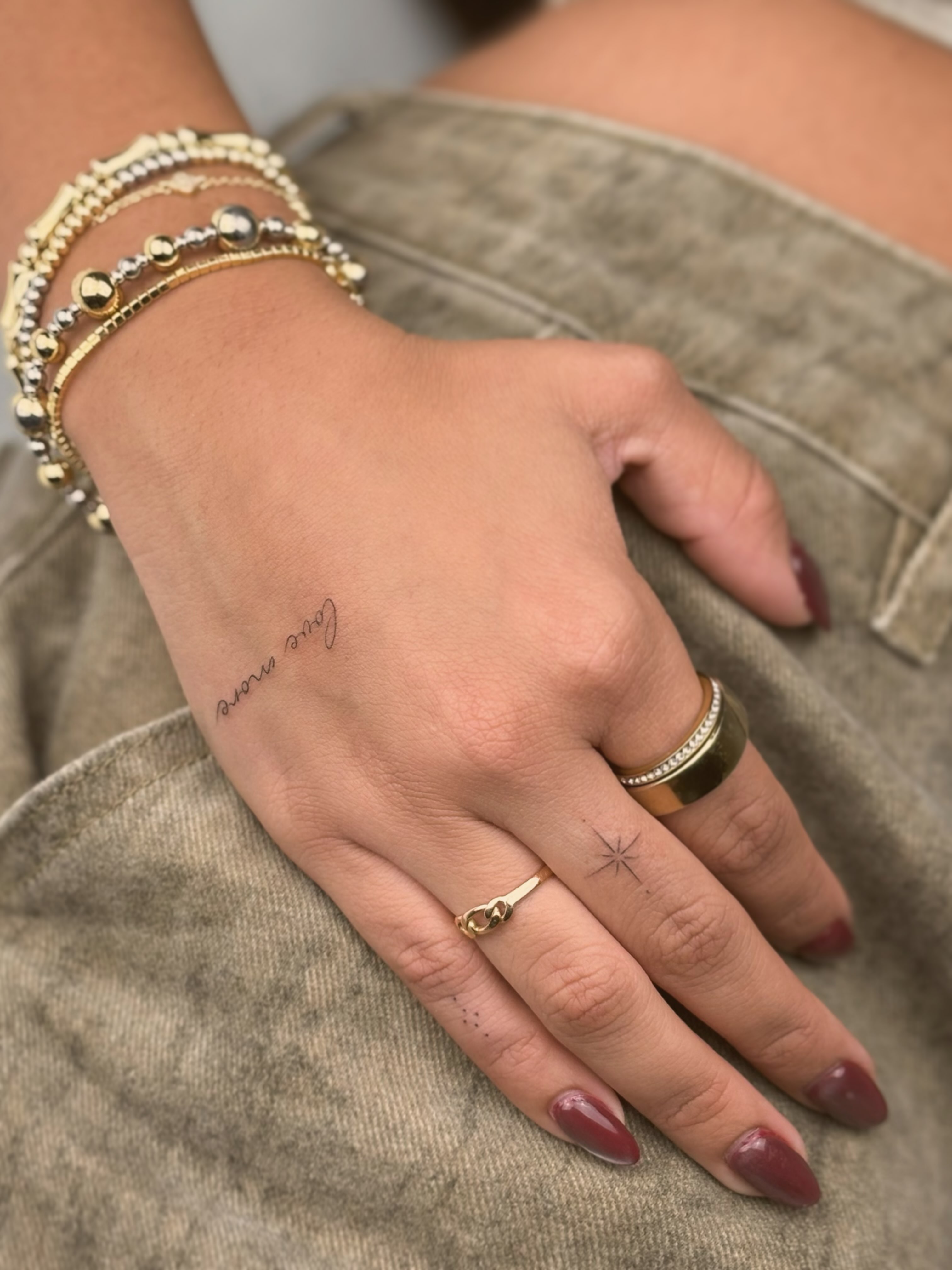 Love more lettering script tattoo on the hand by Christopher Vasquez