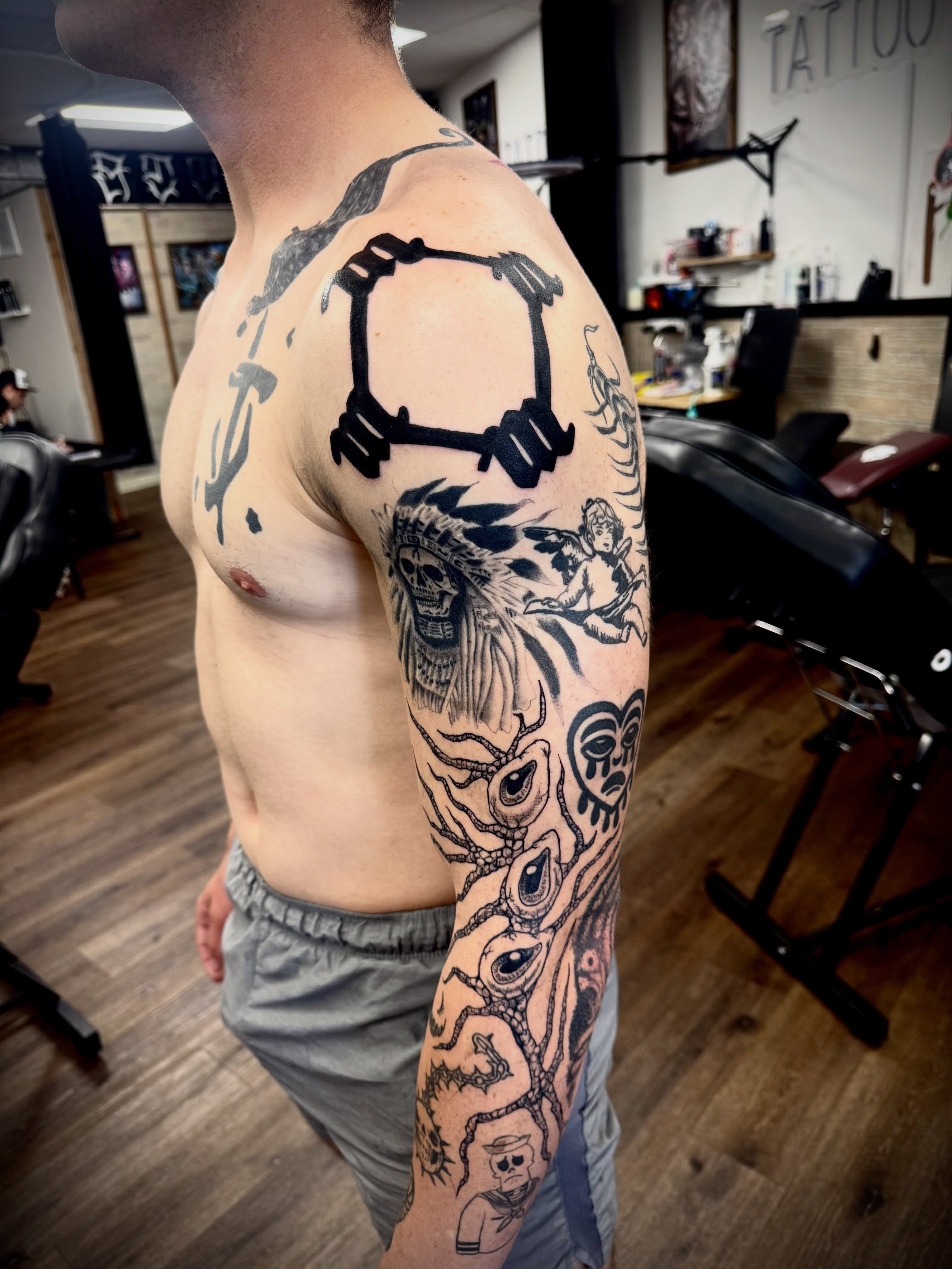 Muscle and headphones black and grey tattoo on the upper arm by LeLe