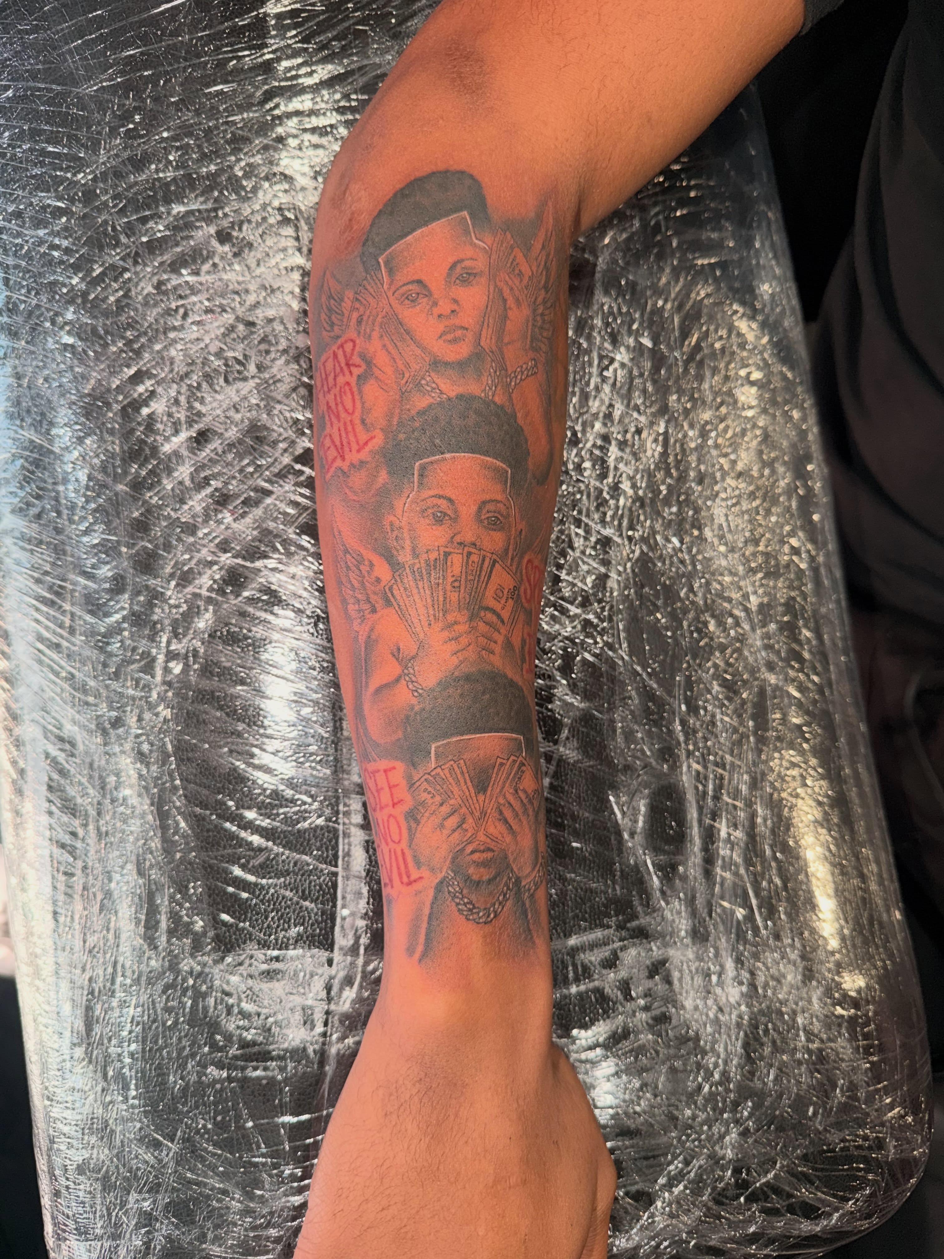 Money and figures black and grey tattoo on the forearm by Clifford Jordan