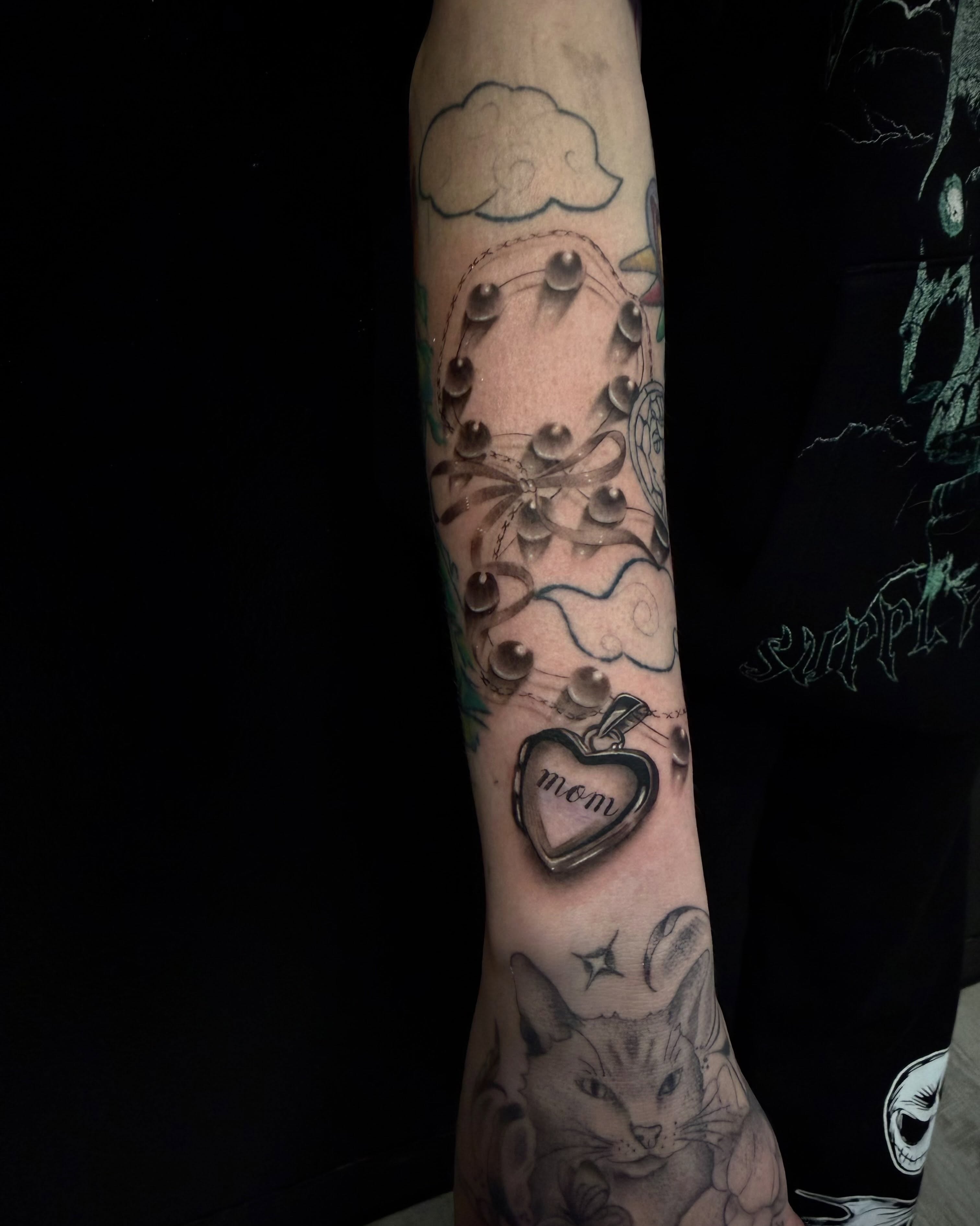 Heart locket black and grey tattoo on the forearm by Amber Lynn